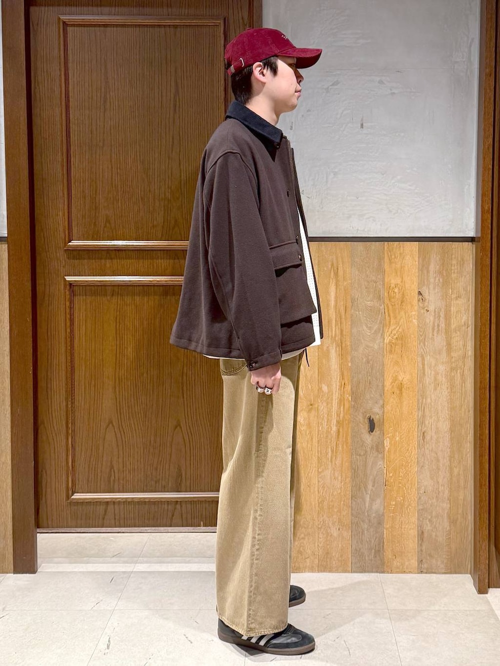 ブラウン系のブルゾン、ホワイト系のニット/セーター、ベージュ系のデニムパンツを着用したメンズの冬コーディネートの7枚目の写真