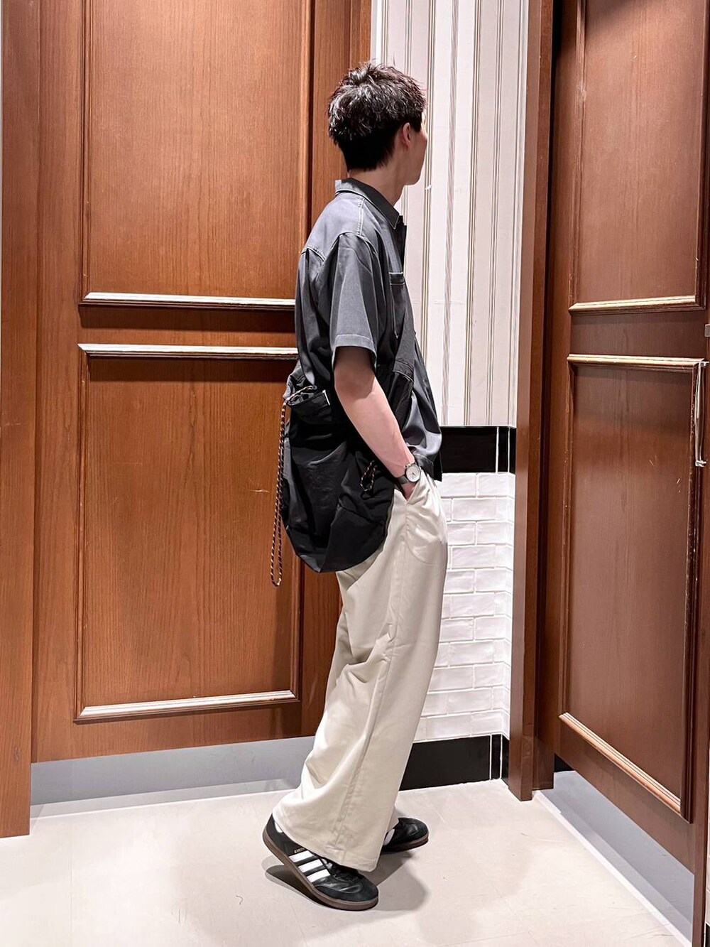 ホワイト系のスラックス、ブラック系のショルダーバッグ、グレー系のシャツ/ブラウスを着用したメンズの夏コーディネートの5枚目の写真