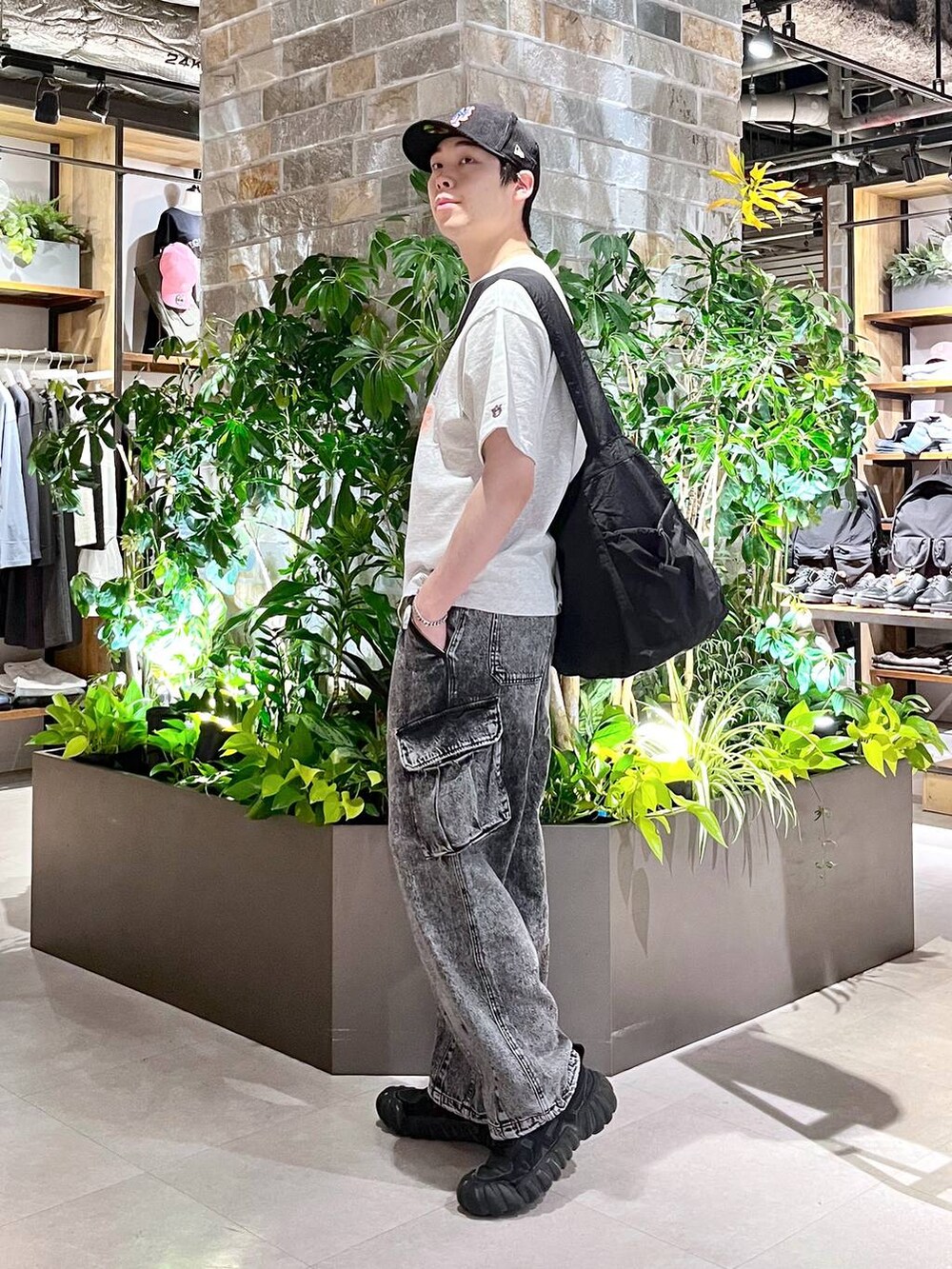 ブラック系のショルダーバッグ、グレー系のデニムパンツ、ホワイト系のTシャツ/カットソーを着用したメンズの春コーディネートの3枚目の写真