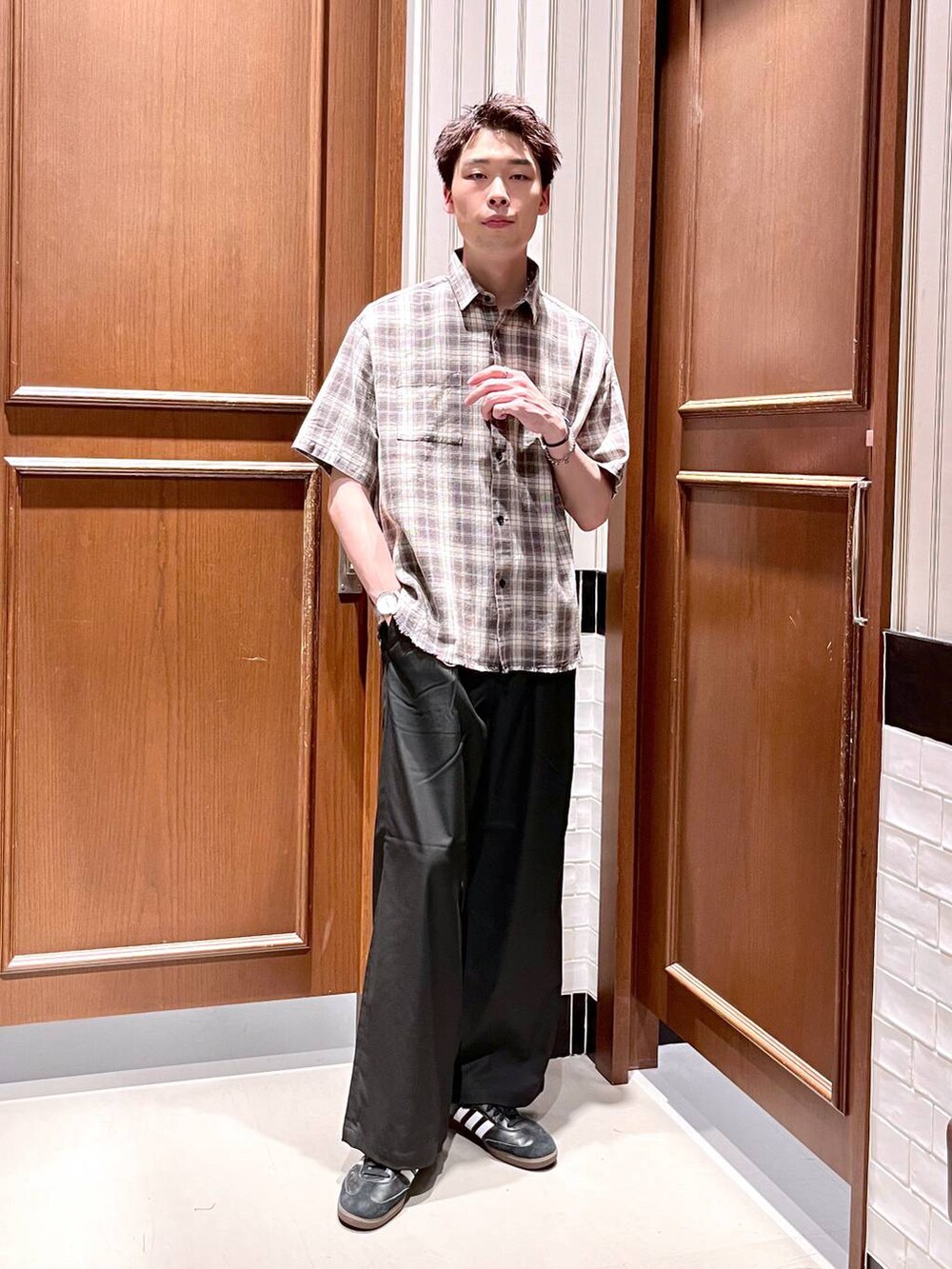 ブラック系のスラックス、グレー系のシャツ/ブラウスを着用したメンズの夏コーディネートの2枚目の写真