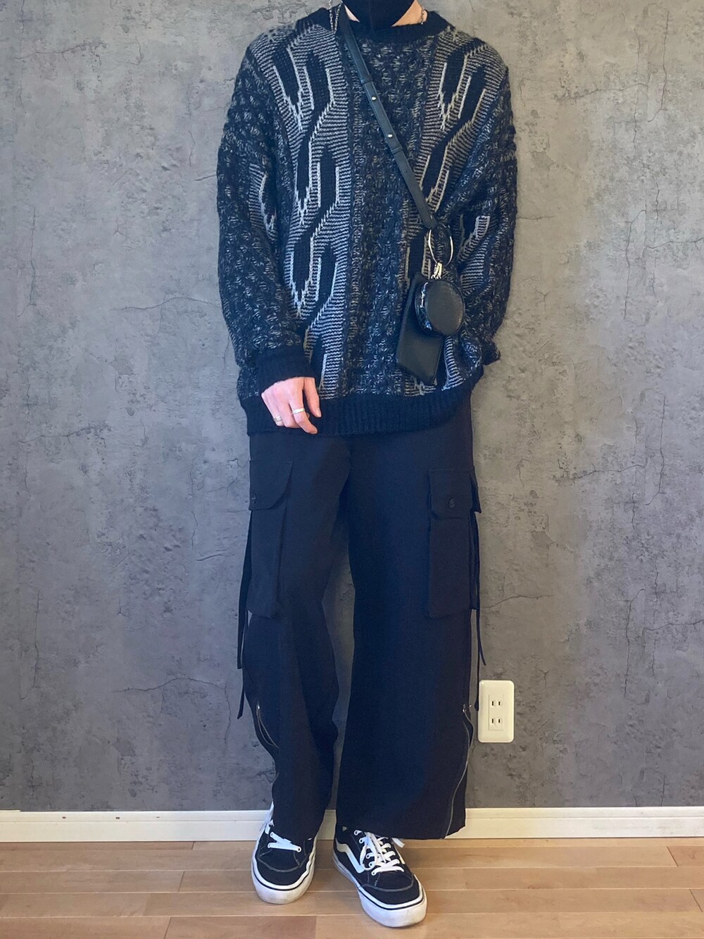 ブラック系のカーゴパンツ、ブラック系のスニーカー、シルバー系のネックレスを着用したメンズの冬コーディネートの2枚目の写真