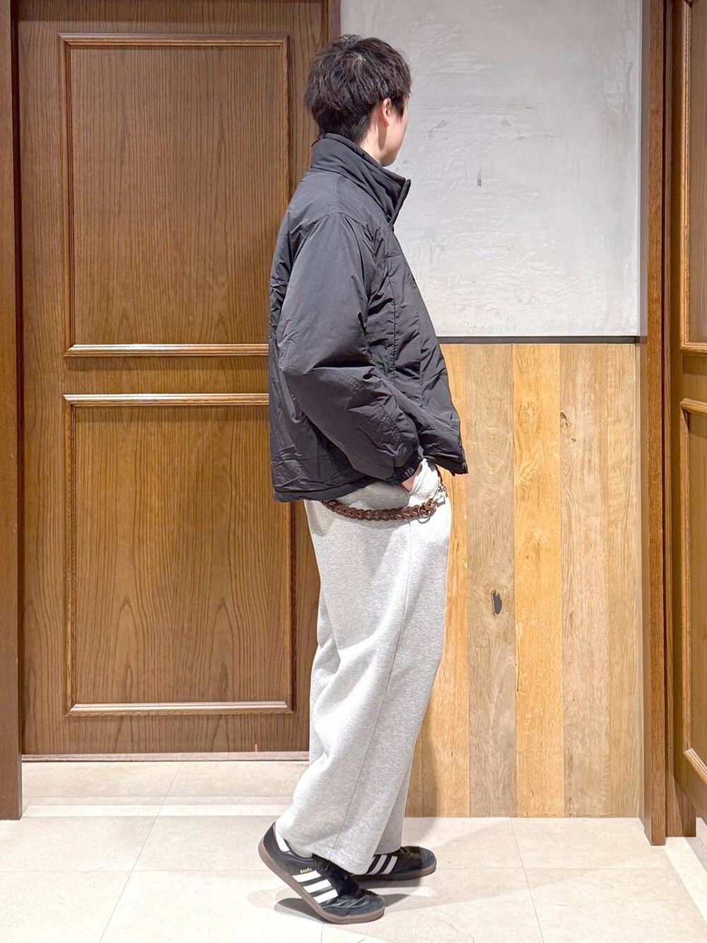 ブラック系のダウンジャケット/コート、ブルー系のニット/セーター、グレー系のスウェットパンツを着用したメンズの冬コーディネートの6枚目の写真