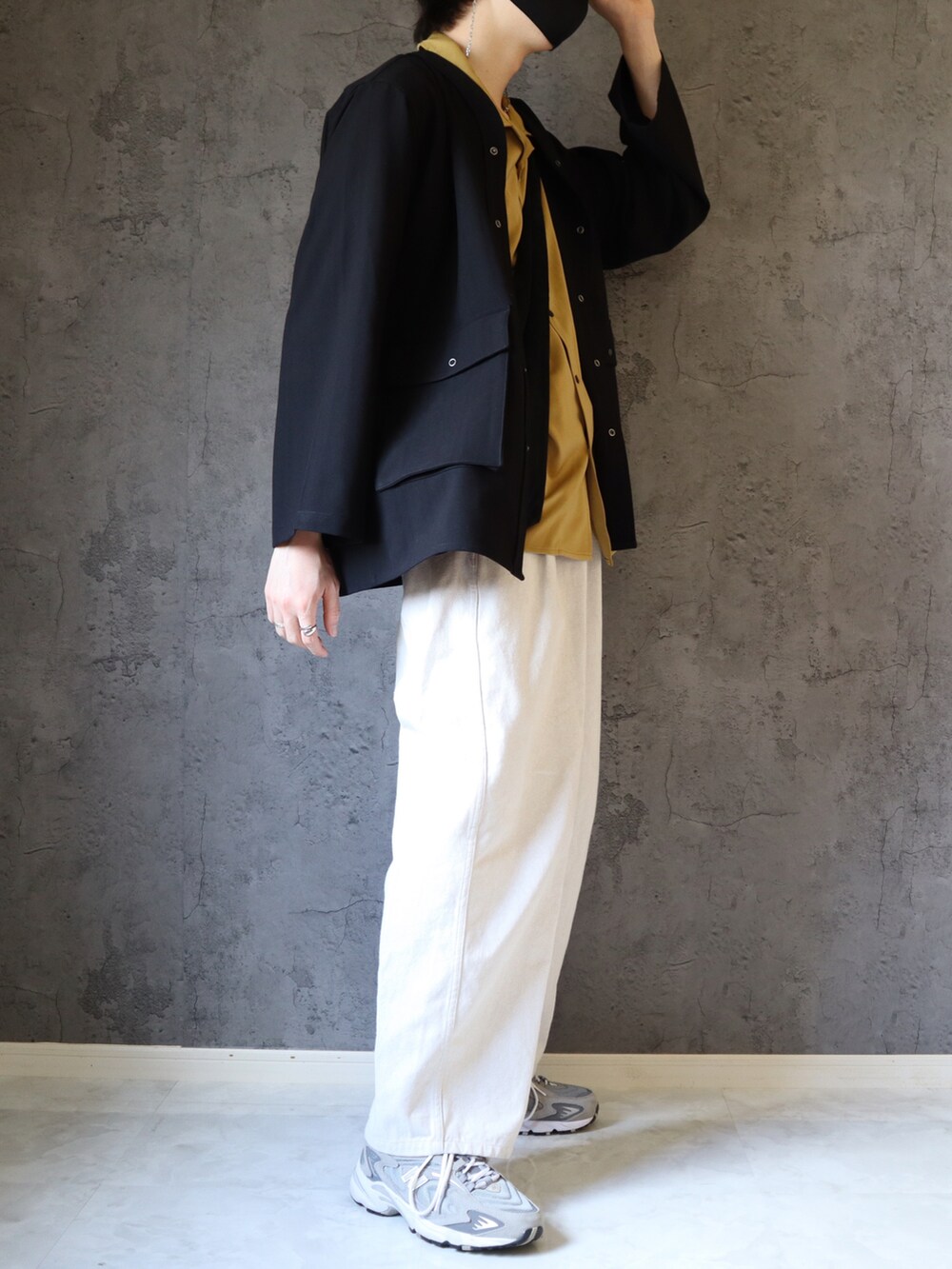 イエロー系のシャツ/ブラウス、ブラック系のカーディガン/ボレロ、ホワイト系のスラックスを着用したメンズの春コーディネートの2枚目の写真