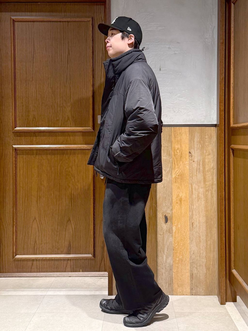 ブラック系のデニムパンツ、グリーン系のニット/セーター、ブラック系のダウンジャケット/コートを着用したメンズの冬コーディネートの5枚目の写真