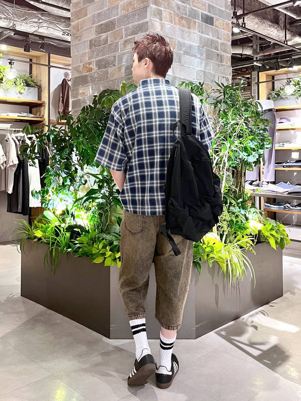 ブラック系のバックパック/リュック、ホワイト系のタンクトップ、グレー系のデニムパンツを着用したメンズの夏コーディネートの3枚目の写真