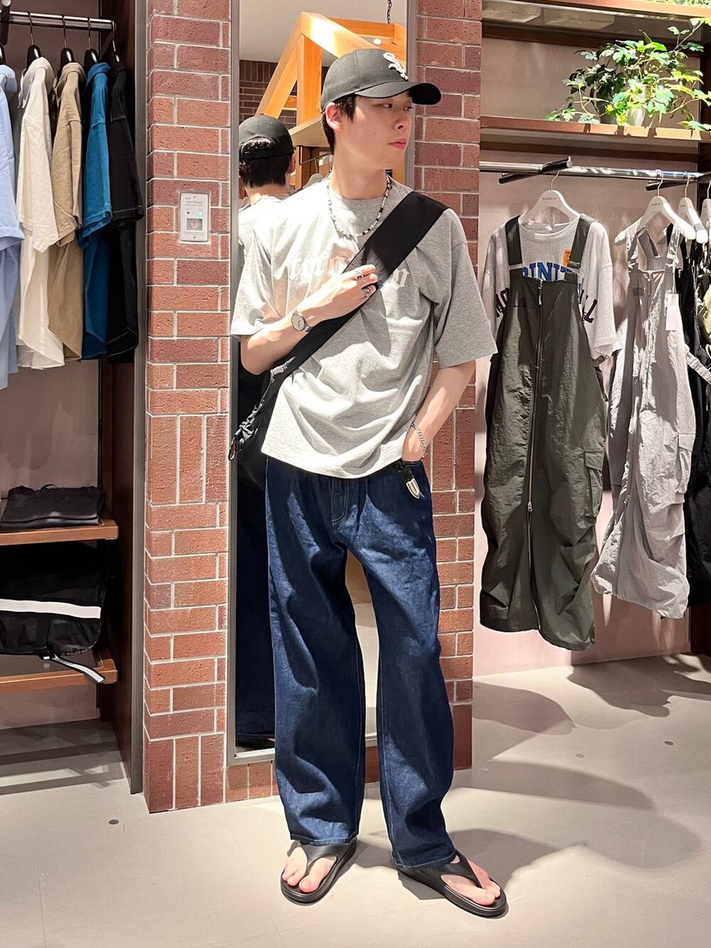 ブルー系のデニムパンツ、ブラック系のショルダーバッグ、グレー系のTシャツ/カットソーを着用したメンズの夏コーディネートの2枚目の写真