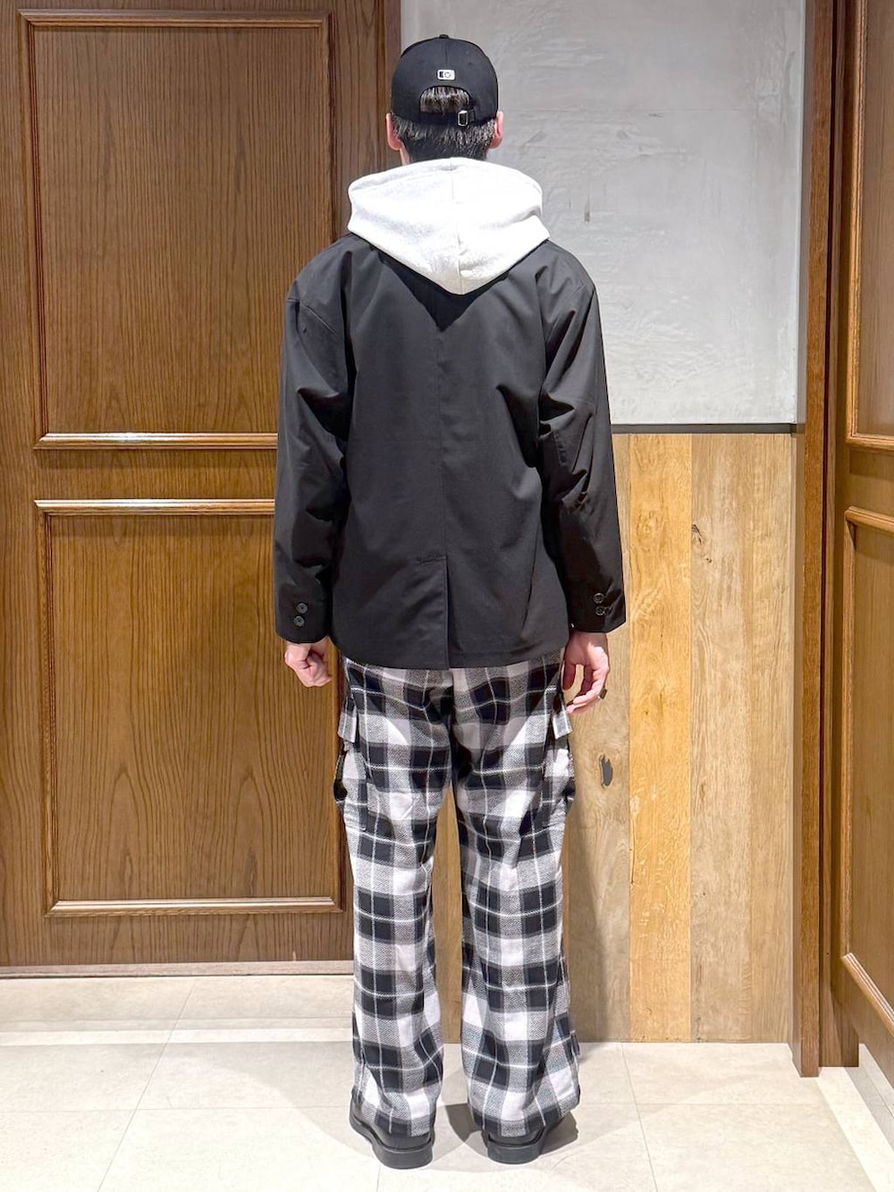 ブラック系のテーラードジャケット、グレー系のカーゴパンツ、グレー系のパーカーを着用したメンズの冬コーディネートの4枚目の写真