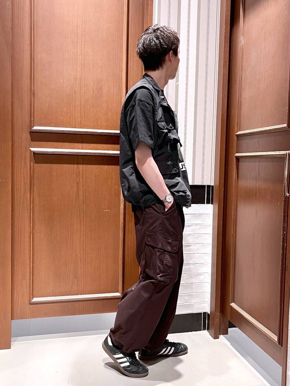 ブラウン系のカーゴパンツ、ブラック系のベスト、ブラック系のTシャツ/カットソーを着用したメンズの夏コーディネートの5枚目の写真