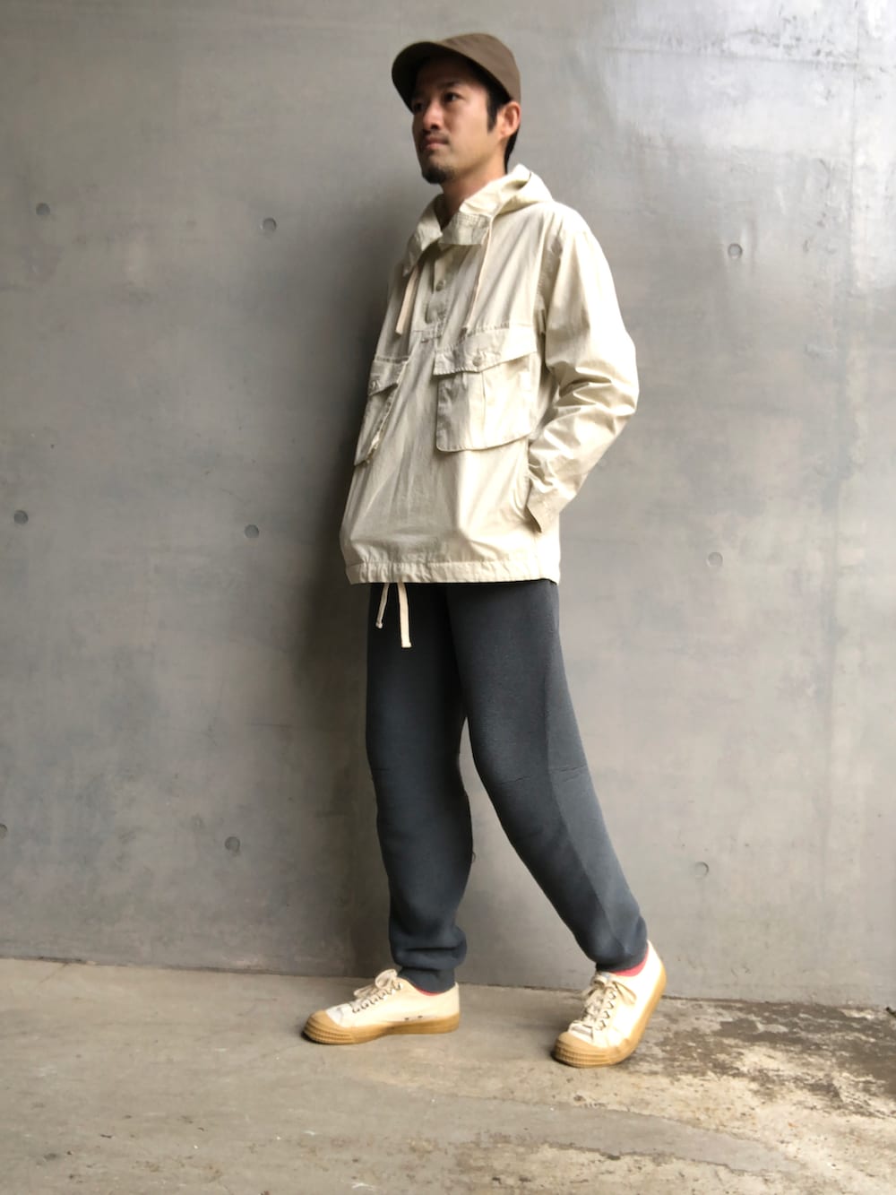 ホワイト系のミリタリージャケット、グレー系のスウェットパンツ、ホワイト系のスニーカーを着用したメンズの春コーディネートの2枚目の写真