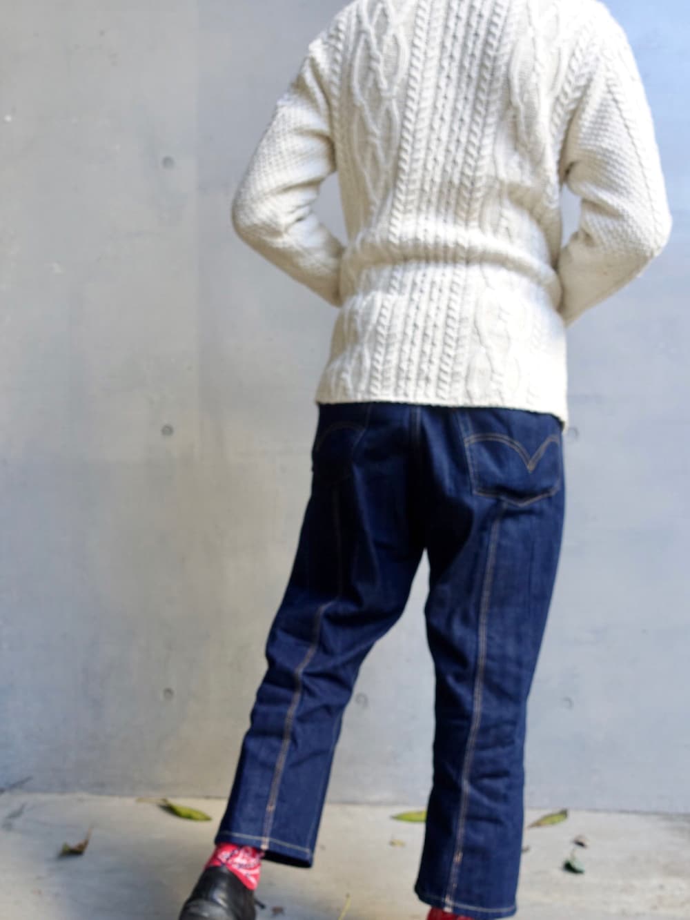 ホワイト系のカーディガン/ボレロ、ブルー系のデニムパンツ、ブラック系のスニーカーを着用したメンズの秋コーディネートの2枚目の写真