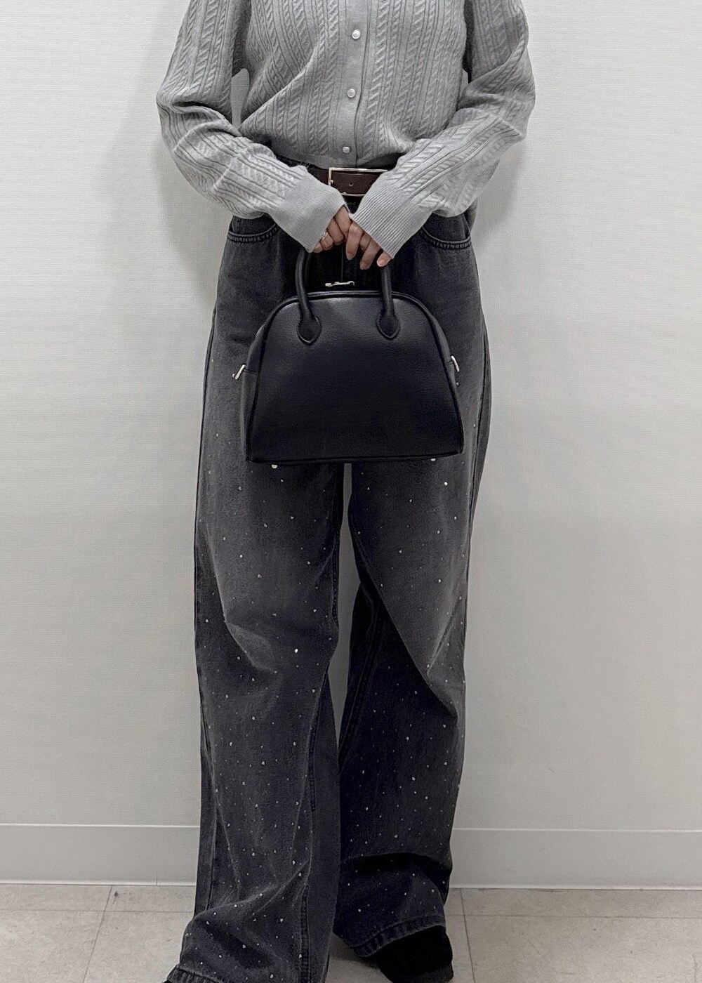 ブラック系のデニムパンツ、グレー系のカーディガン/ボレロ、ブラック系のショルダーバッグを着用したレディースの秋コーディネートの9枚目の写真