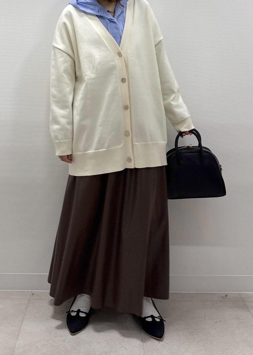 ブラウン系のスカート、ブラック系のパンプス、ブルー系のシャツ/ブラウスを着用したレディースの秋コーディネートの8枚目の写真