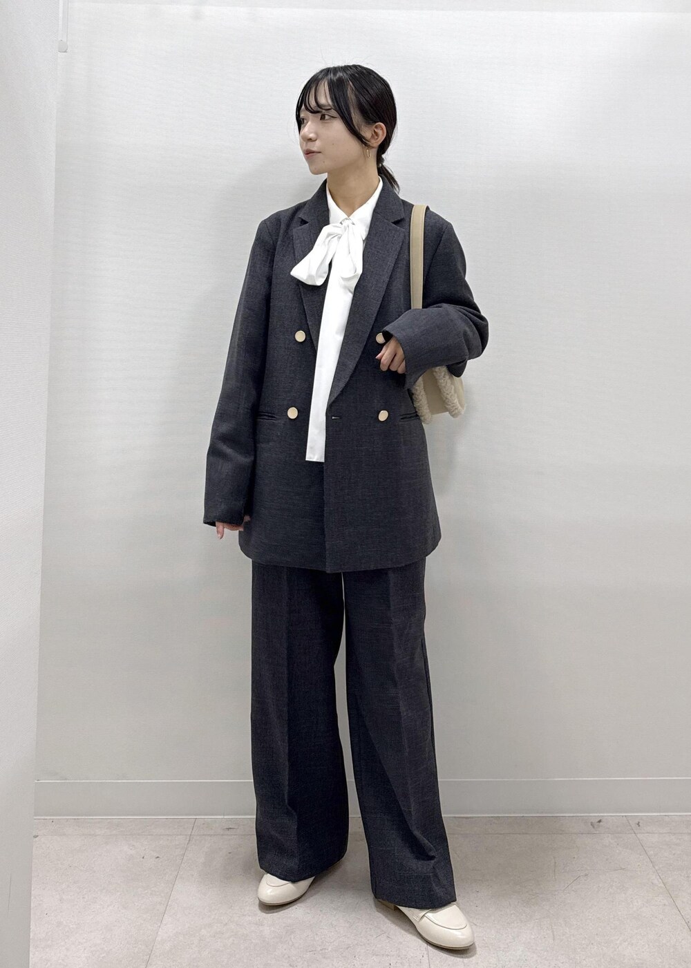 ホワイト系のパンプス、ホワイト系のシャツ/ブラウス、グレー系のテーラードジャケットを着用したレディースの秋コーディネートの10枚目の写真