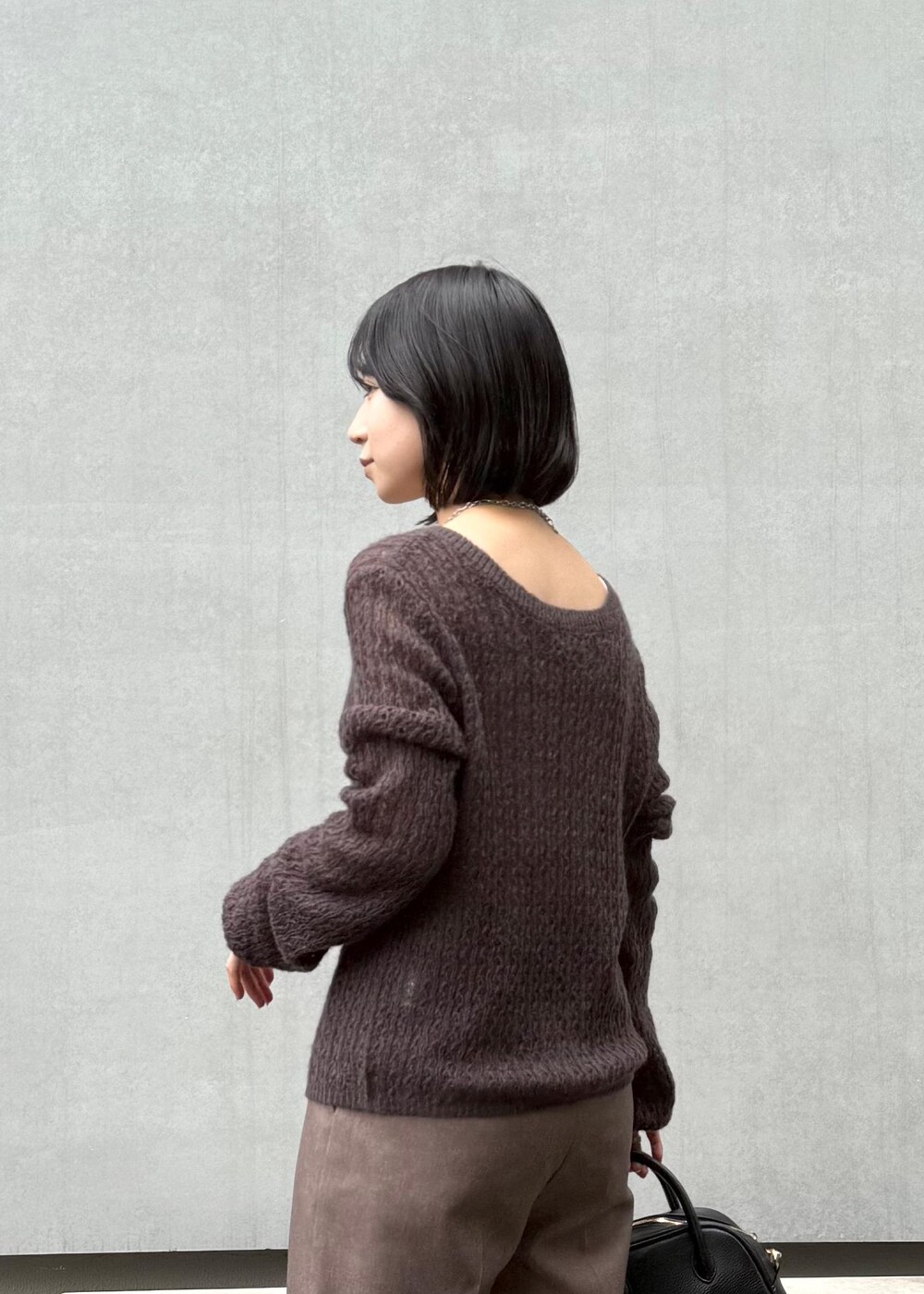 ブラウン系のカーディガン/ボレロ、ベージュ系のスラックス、ブラック系のボストンバッグを着用したレディースの秋コーディネートの5枚目の写真