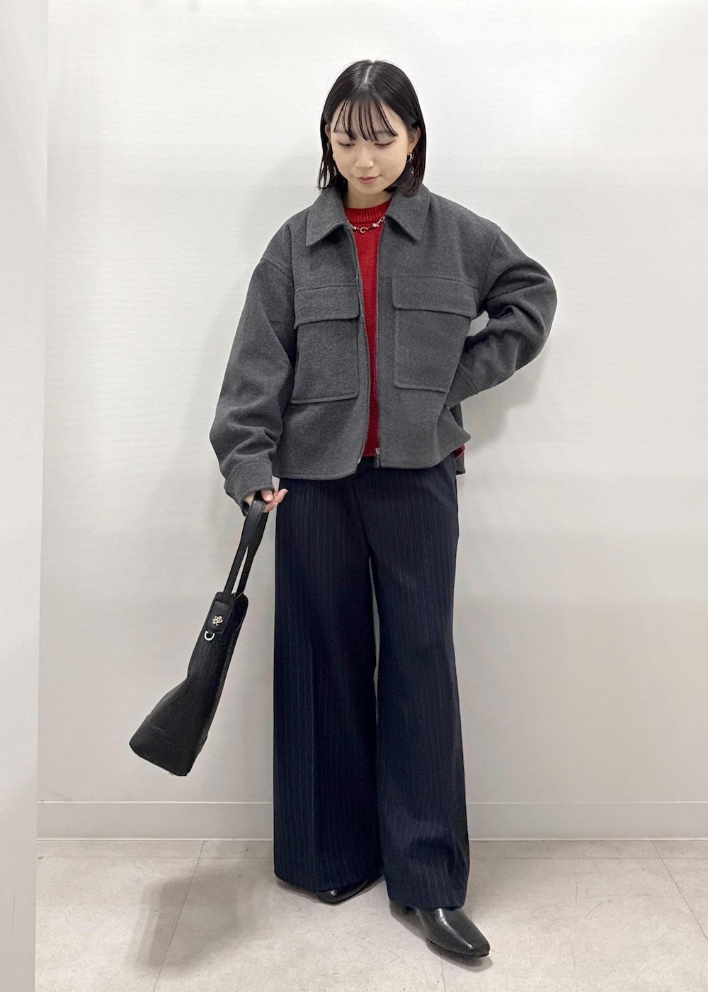 ブラック系のショルダーバッグ、ブルー系のその他パンツ、レッド系のニット/セーターを着用したレディースの秋コーディネートの2枚目の写真