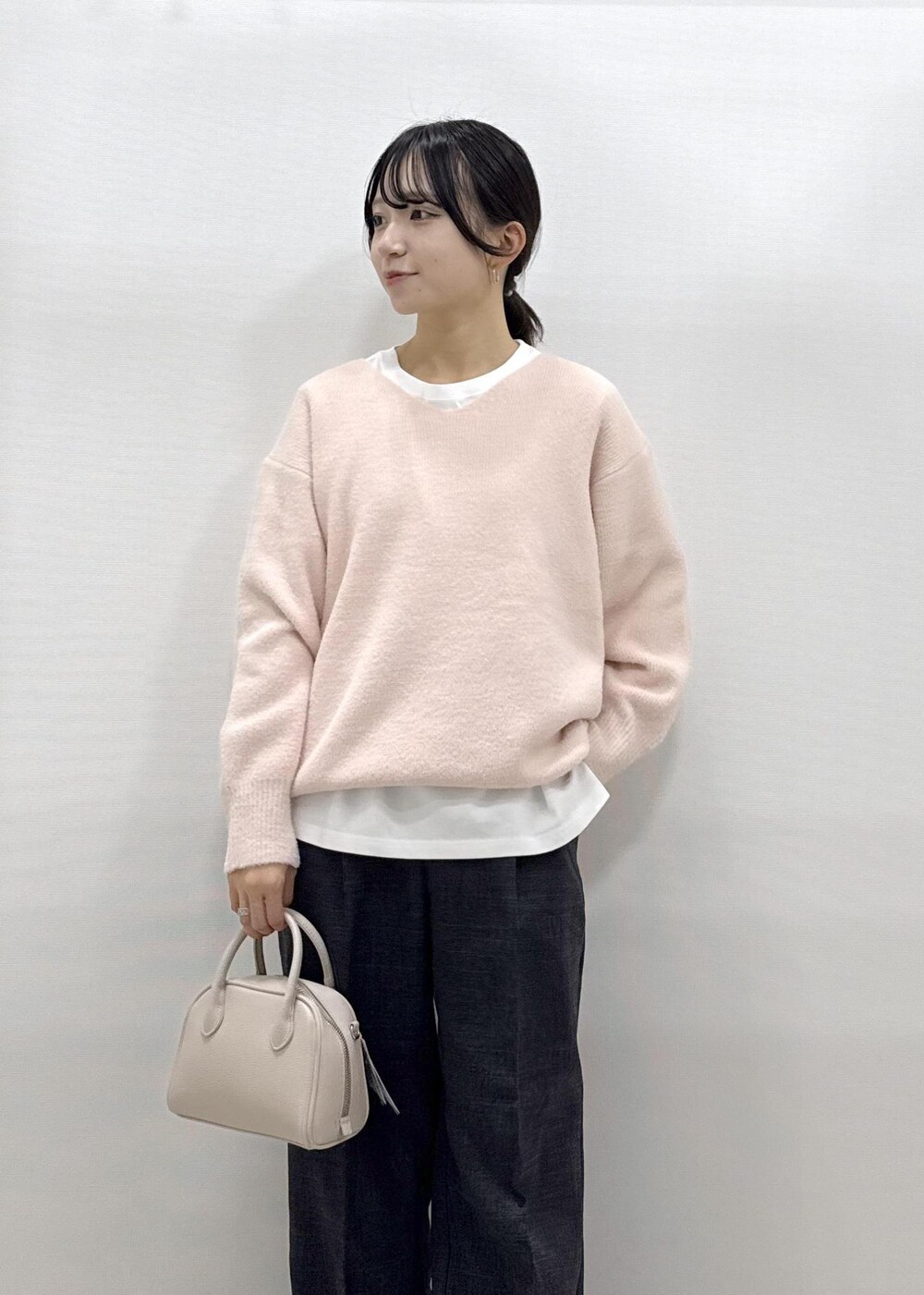 ホワイト系のパンプス、ピンク系のニット/セーター、ホワイト系のTシャツ/カットソーを着用したレディースの秋コーディネートの2枚目の写真