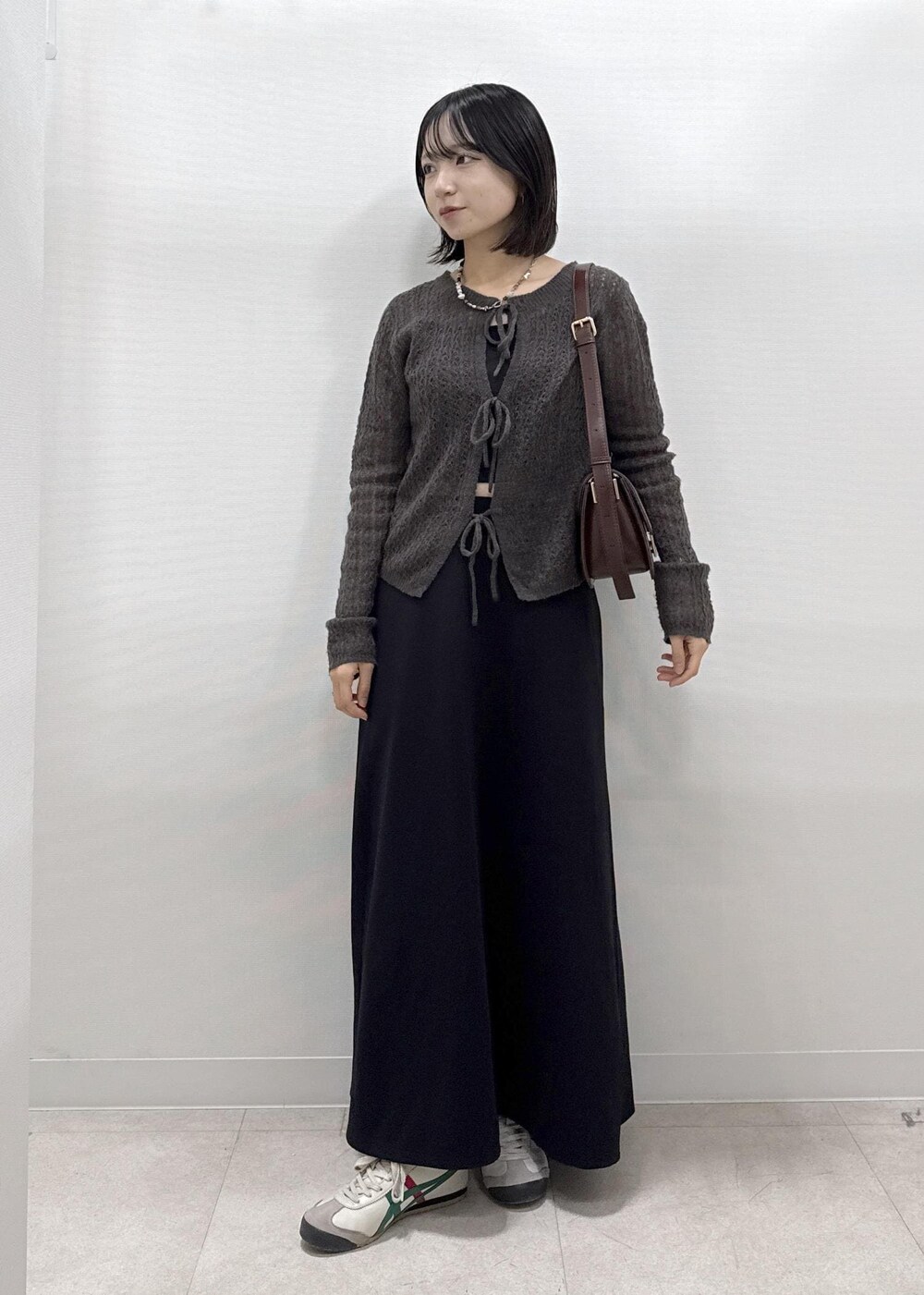 ブラック系のスカート、ブラウン系のカーディガン/ボレロ、レッド系のショルダーバッグを着用したレディースの秋コーディネートの10枚目の写真