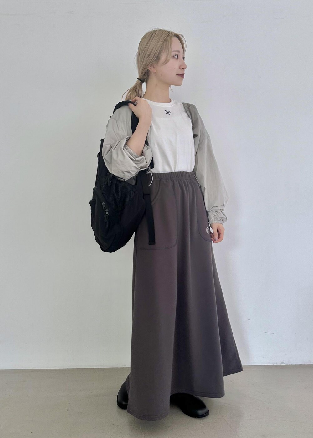 ブラック系のバックパック/リュック、グレー系のスカート、グレー系のその他アウターを着用したレディースの夏コーディネートの4枚目の写真
