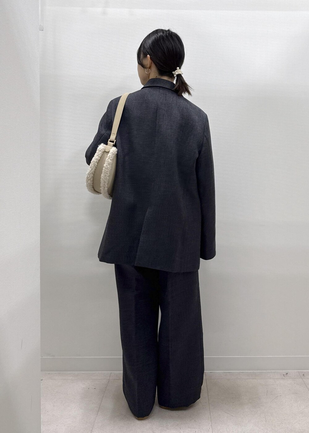 ホワイト系のパンプス、ホワイト系のシャツ/ブラウス、グレー系のテーラードジャケットを着用したレディースの秋コーディネートの4枚目の写真