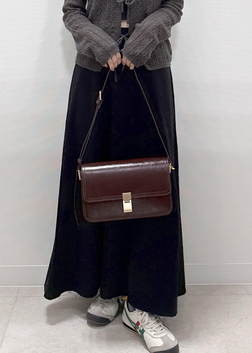 ブラック系のスカート、ブラウン系のカーディガン/ボレロ、レッド系のショルダーバッグを着用したレディースの秋コーディネートの8枚目の写真