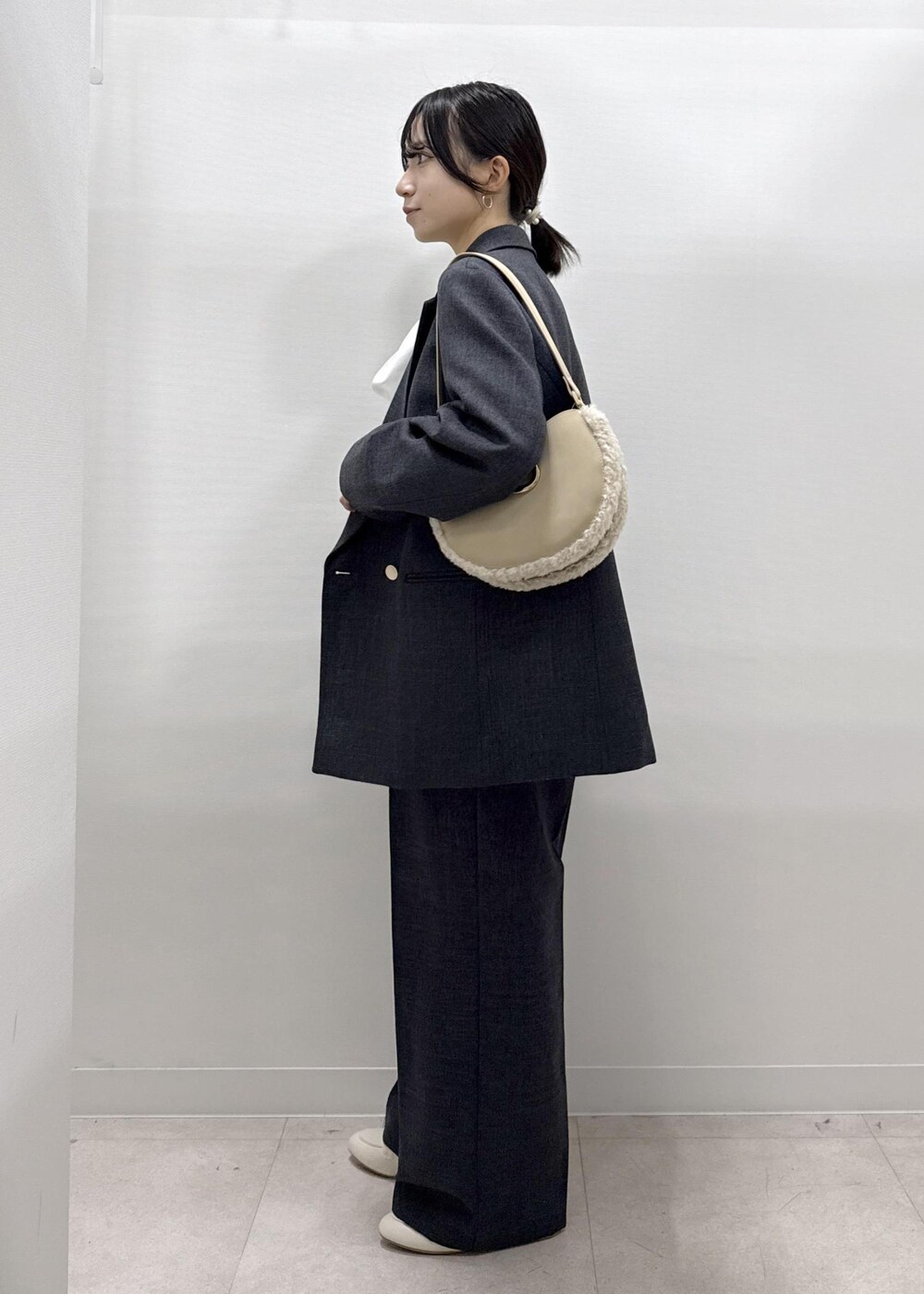 ホワイト系のパンプス、ホワイト系のシャツ/ブラウス、グレー系のテーラードジャケットを着用したレディースの秋コーディネートの3枚目の写真