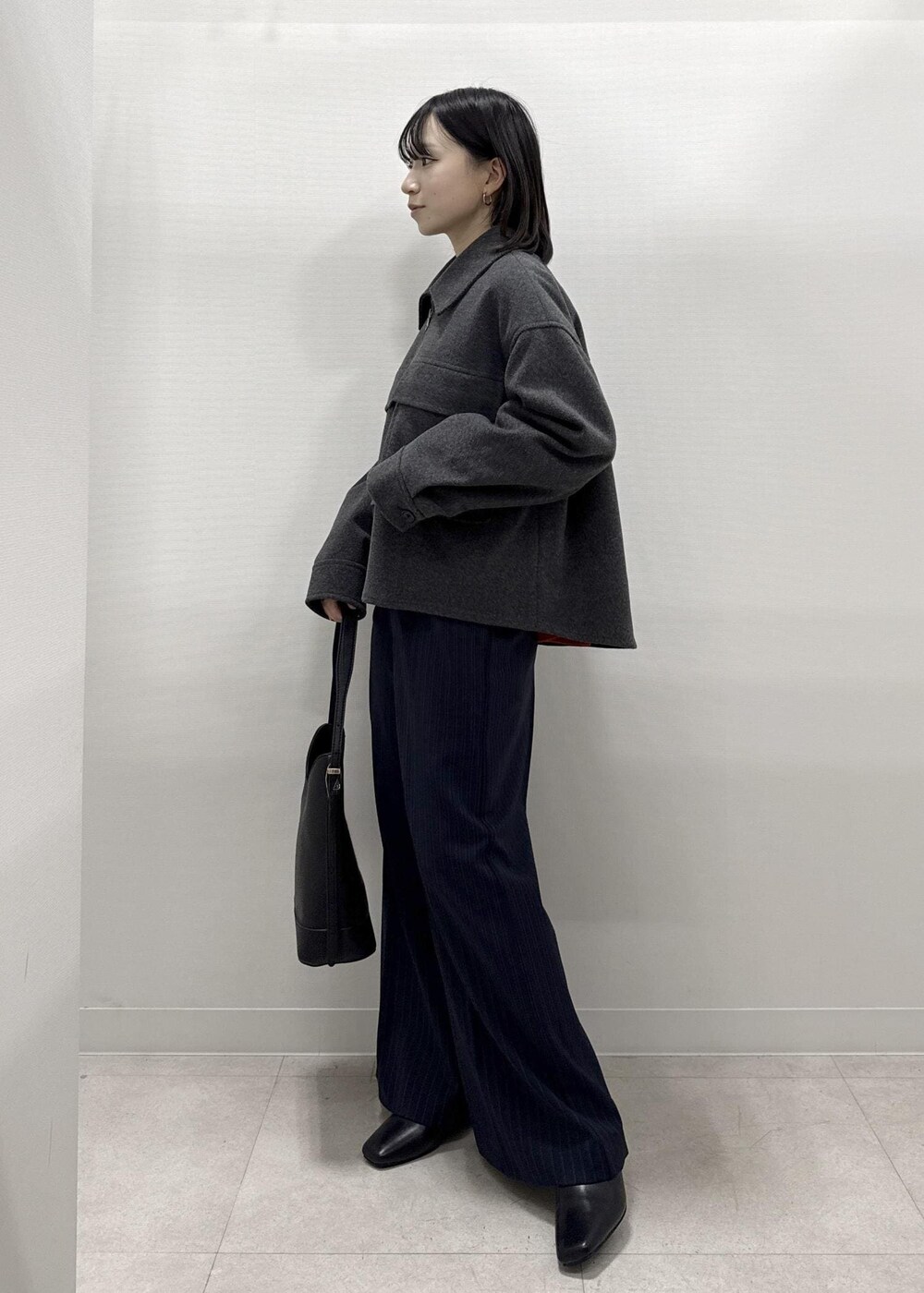 ブラック系のショルダーバッグ、ブルー系のその他パンツ、レッド系のニット/セーターを着用したレディースの秋コーディネートの9枚目の写真