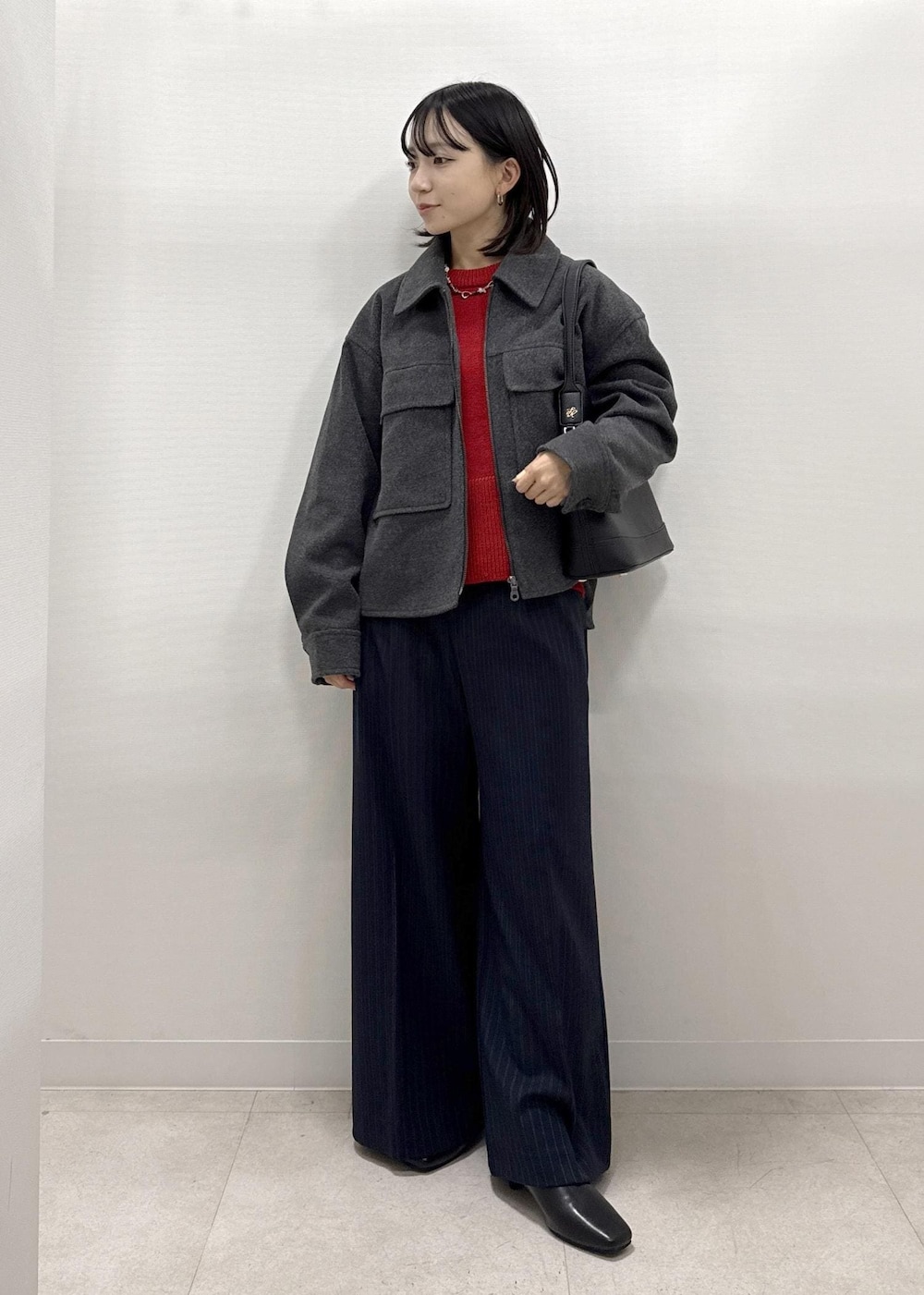 ブラック系のショルダーバッグ、ブルー系のその他パンツ、レッド系のニット/セーターを着用したレディースの秋コーディネートの8枚目の写真