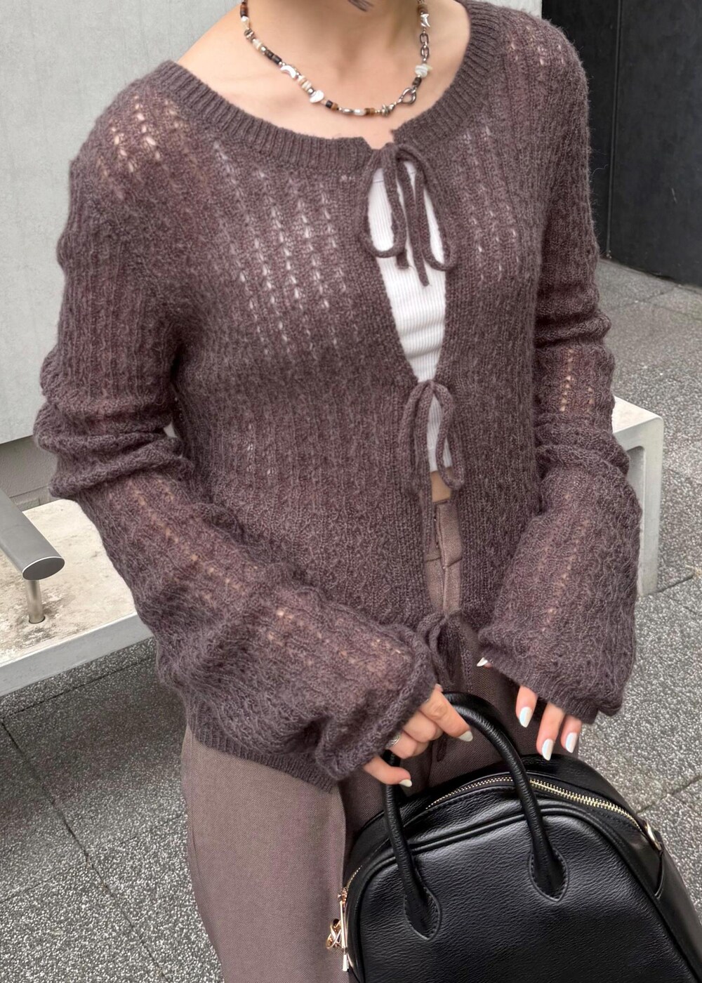 ブラウン系のカーディガン/ボレロ、ベージュ系のスラックス、ブラック系のボストンバッグを着用したレディースの秋コーディネートの9枚目の写真