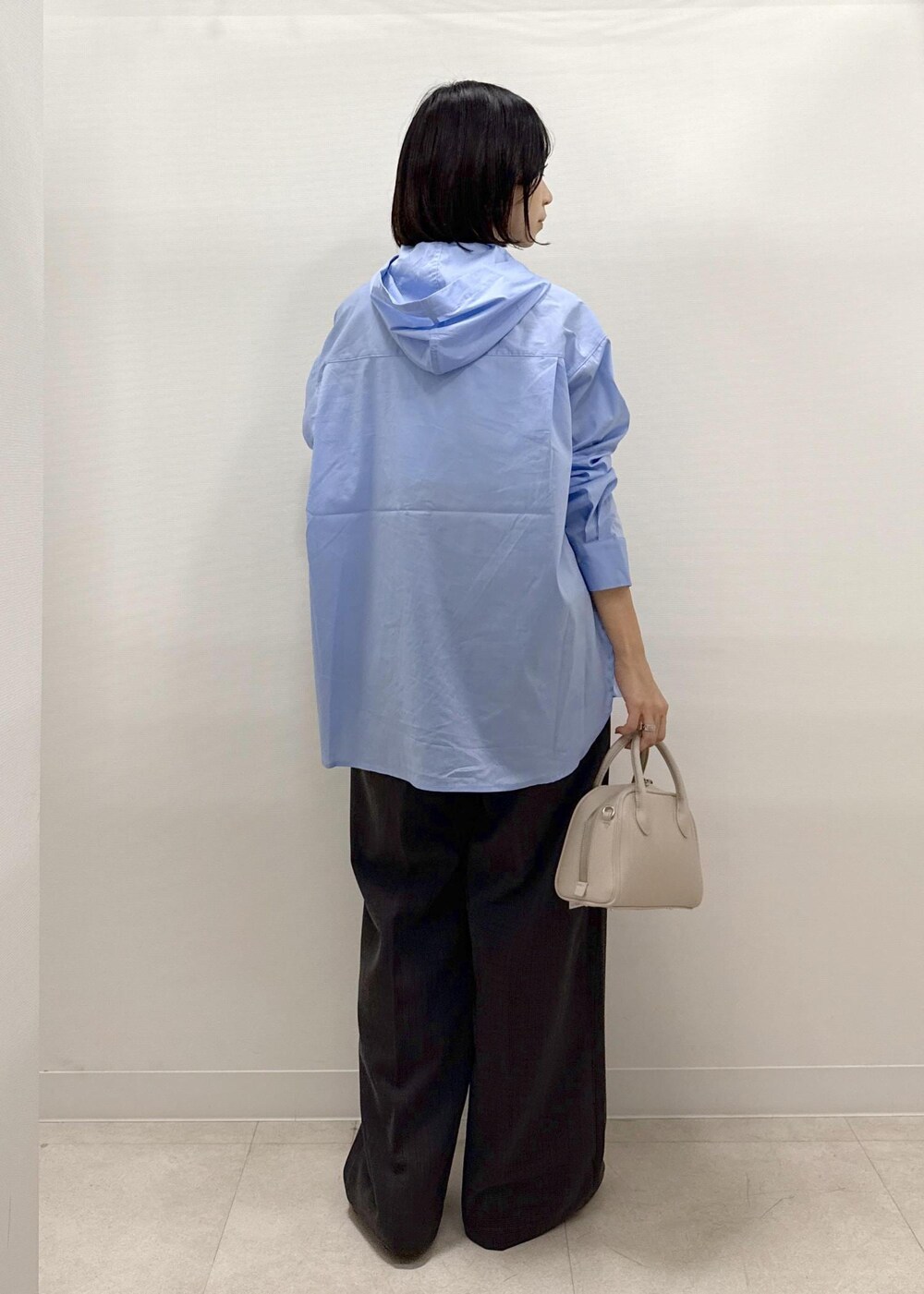 ブラック系のテーラードジャケット、ブラック系のスラックス、ブラック系のパンプスを着用したレディースの秋コーディネートの6枚目の写真