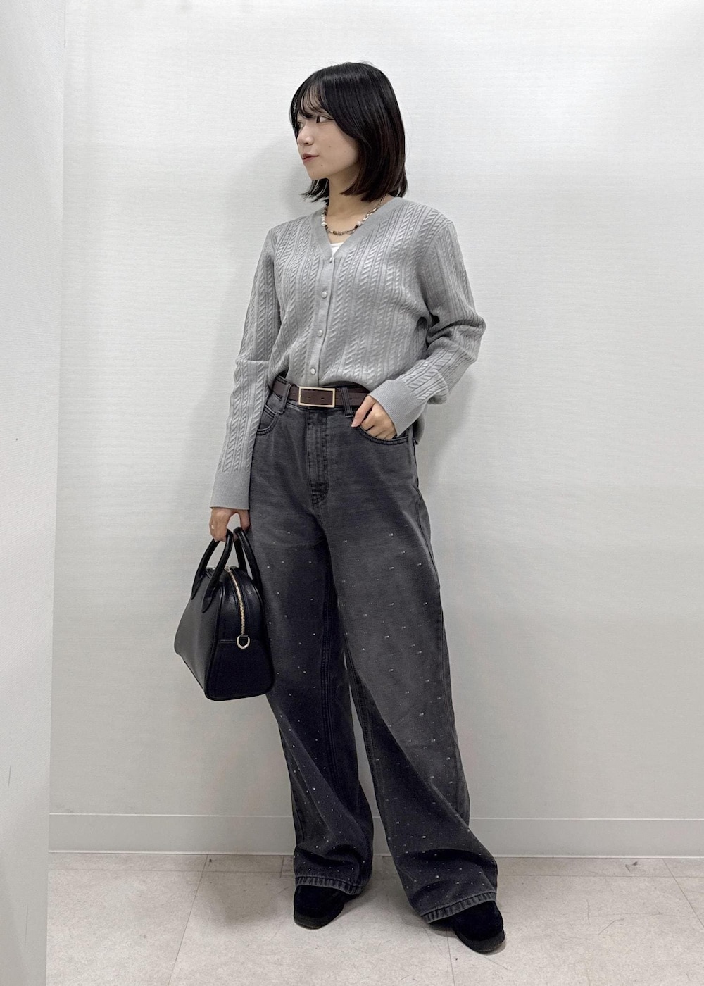 ブラック系のデニムパンツ、グレー系のカーディガン/ボレロ、ブラック系のショルダーバッグを着用したレディースの秋コーディネートの8枚目の写真