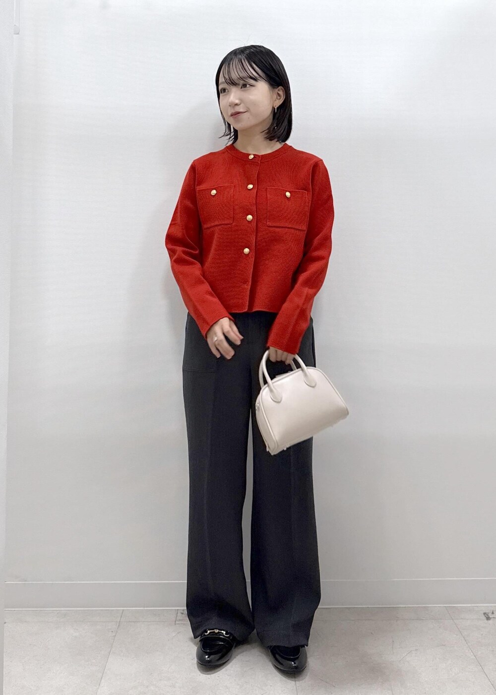 レッド系のカーディガン/ボレロ、グレー系のその他パンツ、ブラック系のローファーを着用したレディースの秋コーディネートの3枚目の写真