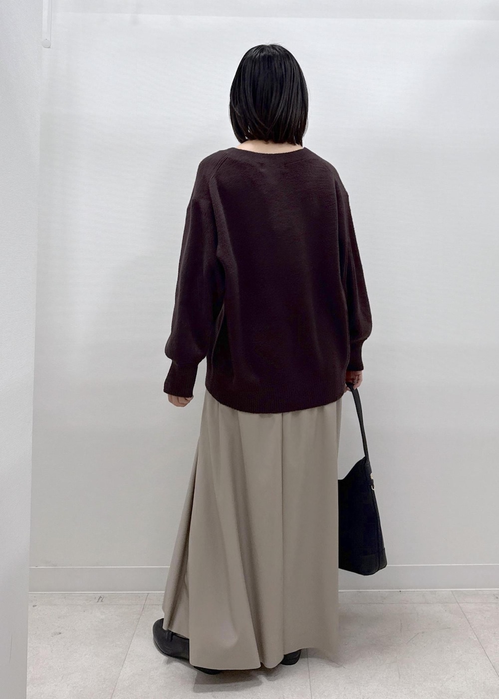 ベージュ系のスカート、ブラウン系のカーディガン/ボレロ、ブラック系のローファーを着用したレディースの秋コーディネートの7枚目の写真