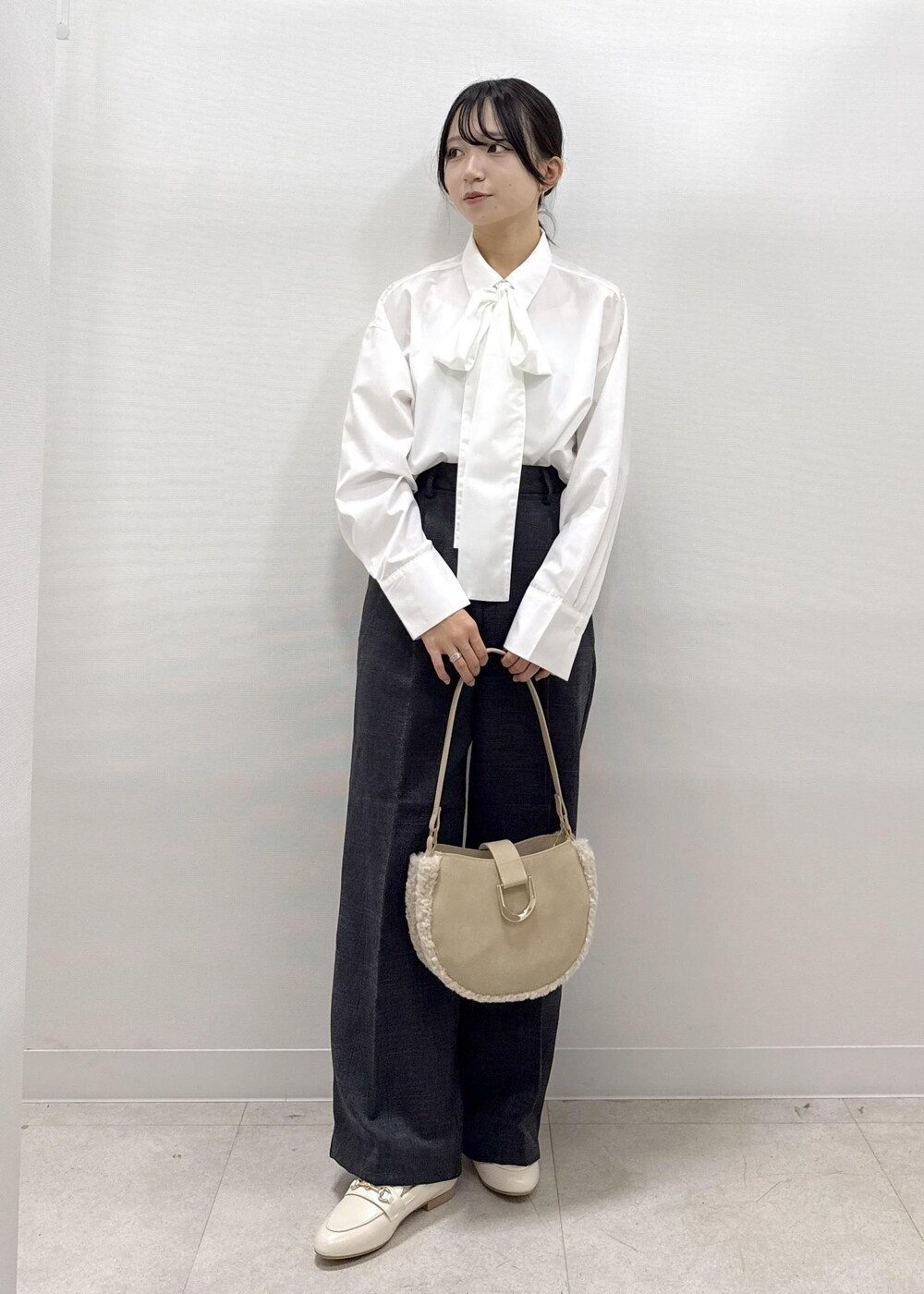 ベージュ系のベスト、ホワイト系のシャツ/ブラウス、グレー系のスラックスを着用したレディースの秋コーディネートの10枚目の写真