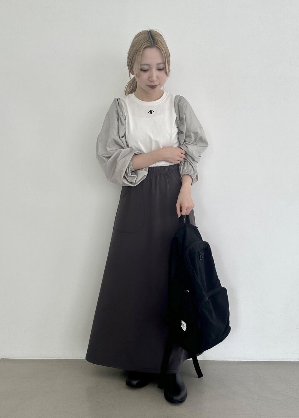 ブラック系のバックパック/リュック、グレー系のスカート、グレー系のその他アウターを着用したレディースの夏コーディネートの6枚目の写真