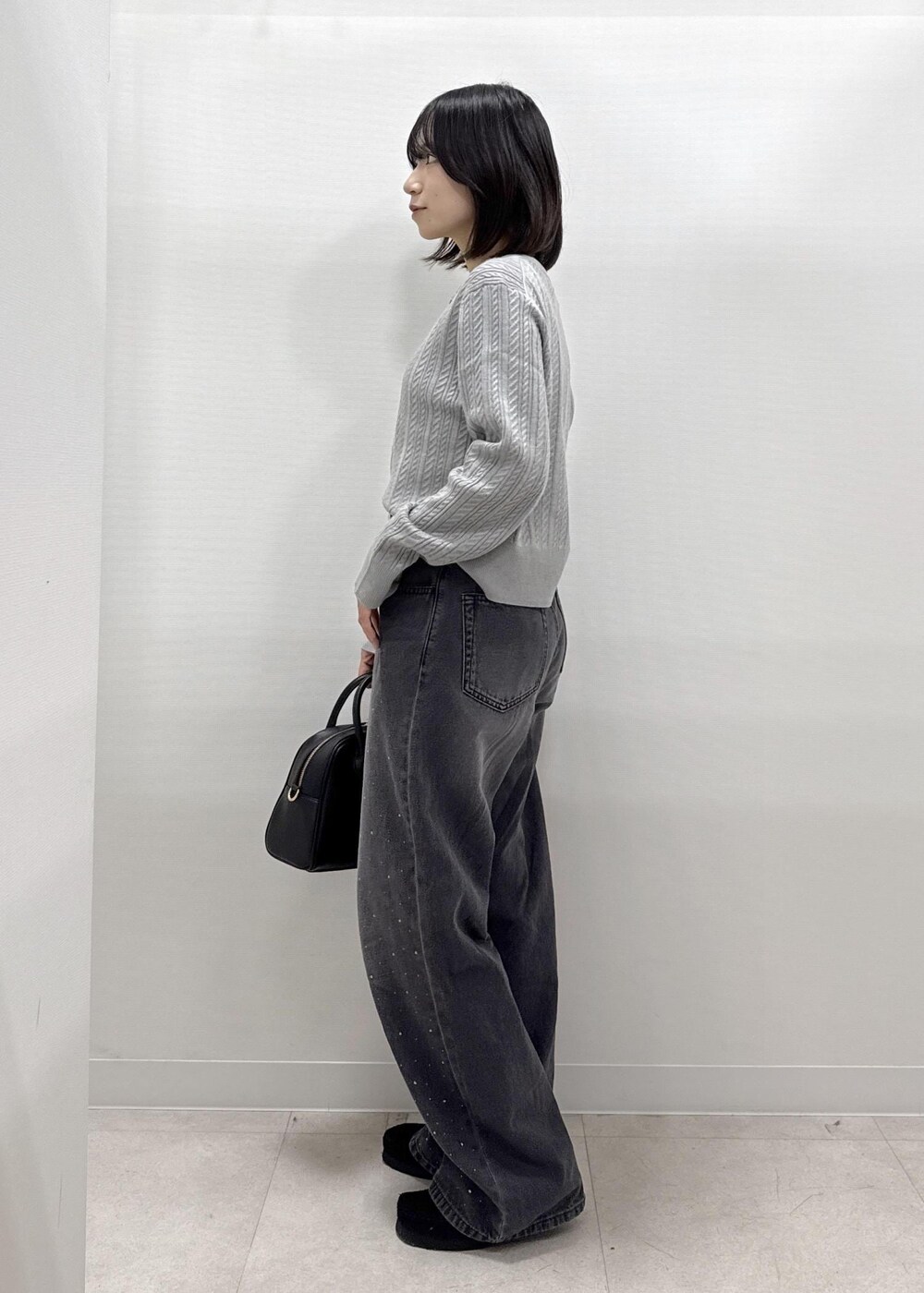 ブラック系のデニムパンツ、グレー系のカーディガン/ボレロ、ブラック系のショルダーバッグを着用したレディースの秋コーディネートの3枚目の写真