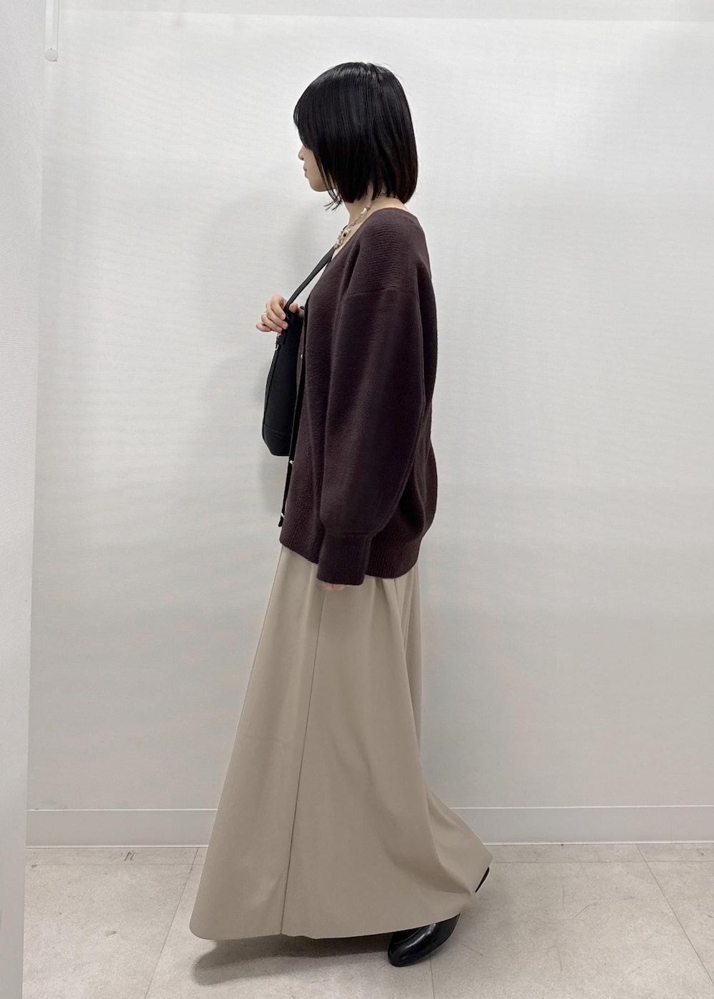 ベージュ系のスカート、ブラウン系のカーディガン/ボレロ、ブラック系のローファーを着用したレディースの秋コーディネートの5枚目の写真