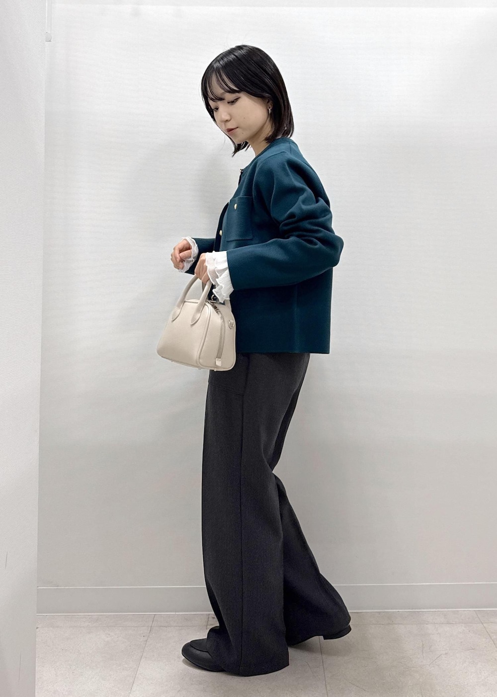 グレー系のその他パンツ、グリーン系のカーディガン/ボレロ、ブラック系のローファーを着用したレディースの秋コーディネートの3枚目の写真