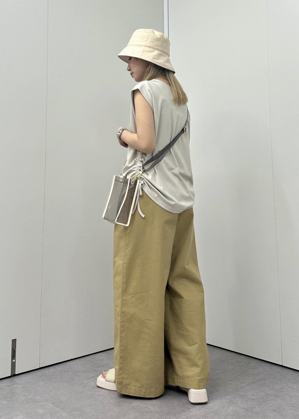 ホワイト系のサンダル、イエロー系のその他パンツ、ベージュ系のTシャツ/カットソーを着用したレディースの春コーディネートの4枚目の写真