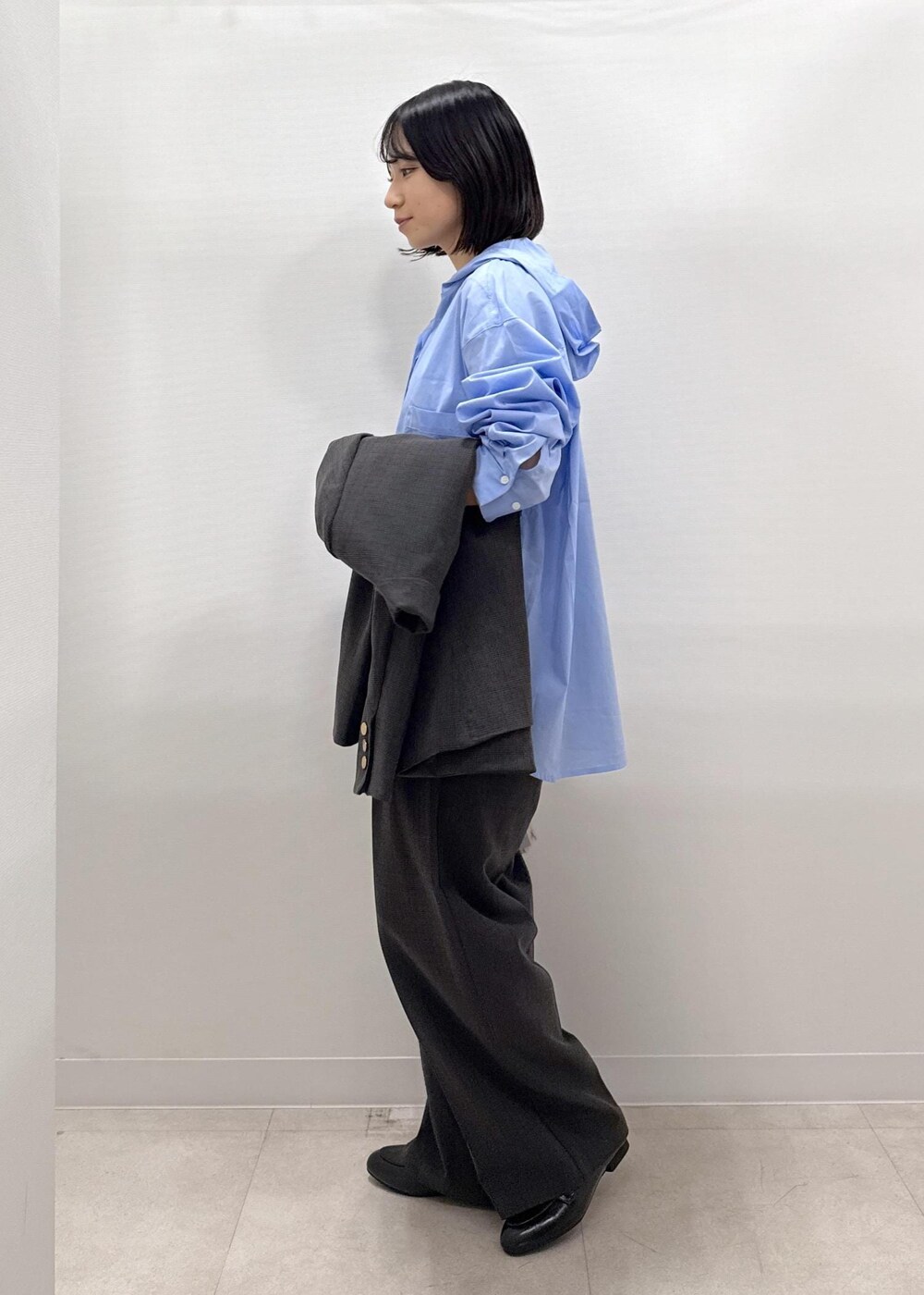 ブラック系のテーラードジャケット、ブラック系のスラックス、ブラック系のパンプスを着用したレディースの秋コーディネートの8枚目の写真