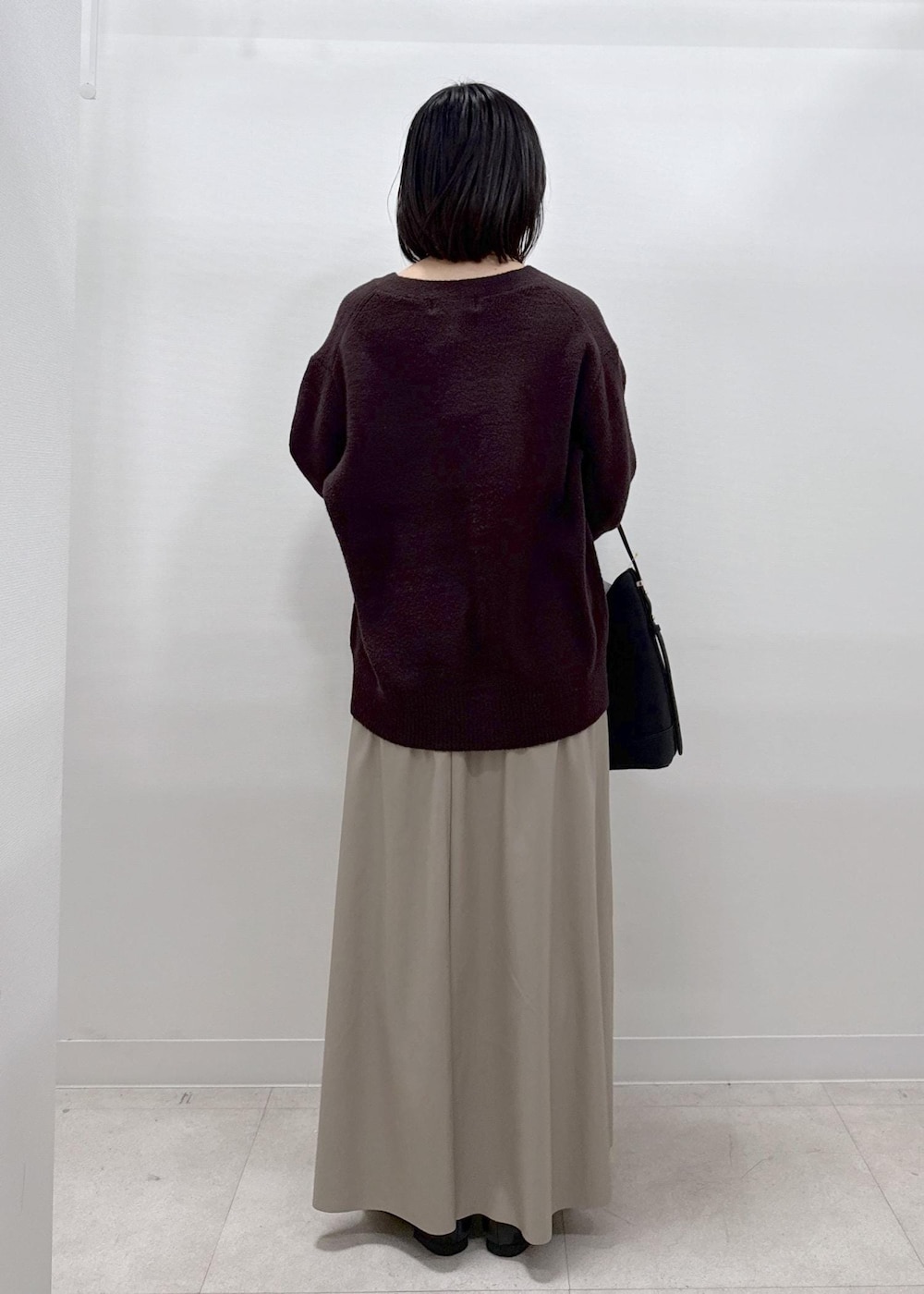 ベージュ系のスカート、ブラウン系のカーディガン/ボレロ、ブラック系のローファーを着用したレディースの秋コーディネートの6枚目の写真