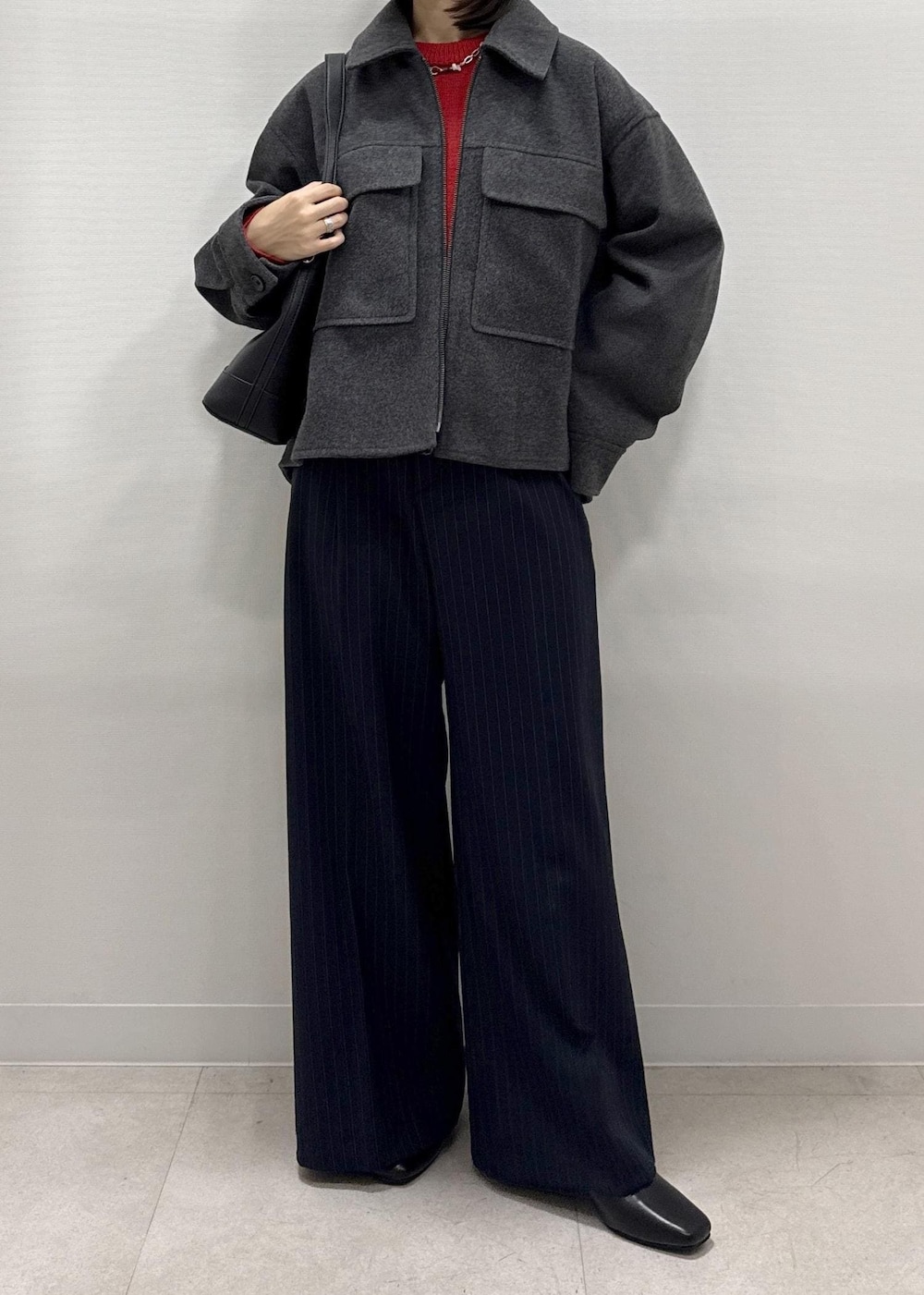 ブラック系のショルダーバッグ、ブルー系のその他パンツ、レッド系のニット/セーターを着用したレディースの秋コーディネートの6枚目の写真