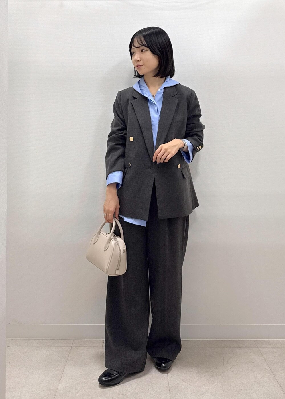 ブラック系のテーラードジャケット、ブラック系のスラックス、ブラック系のパンプスを着用したレディースの秋コーディネートの10枚目の写真