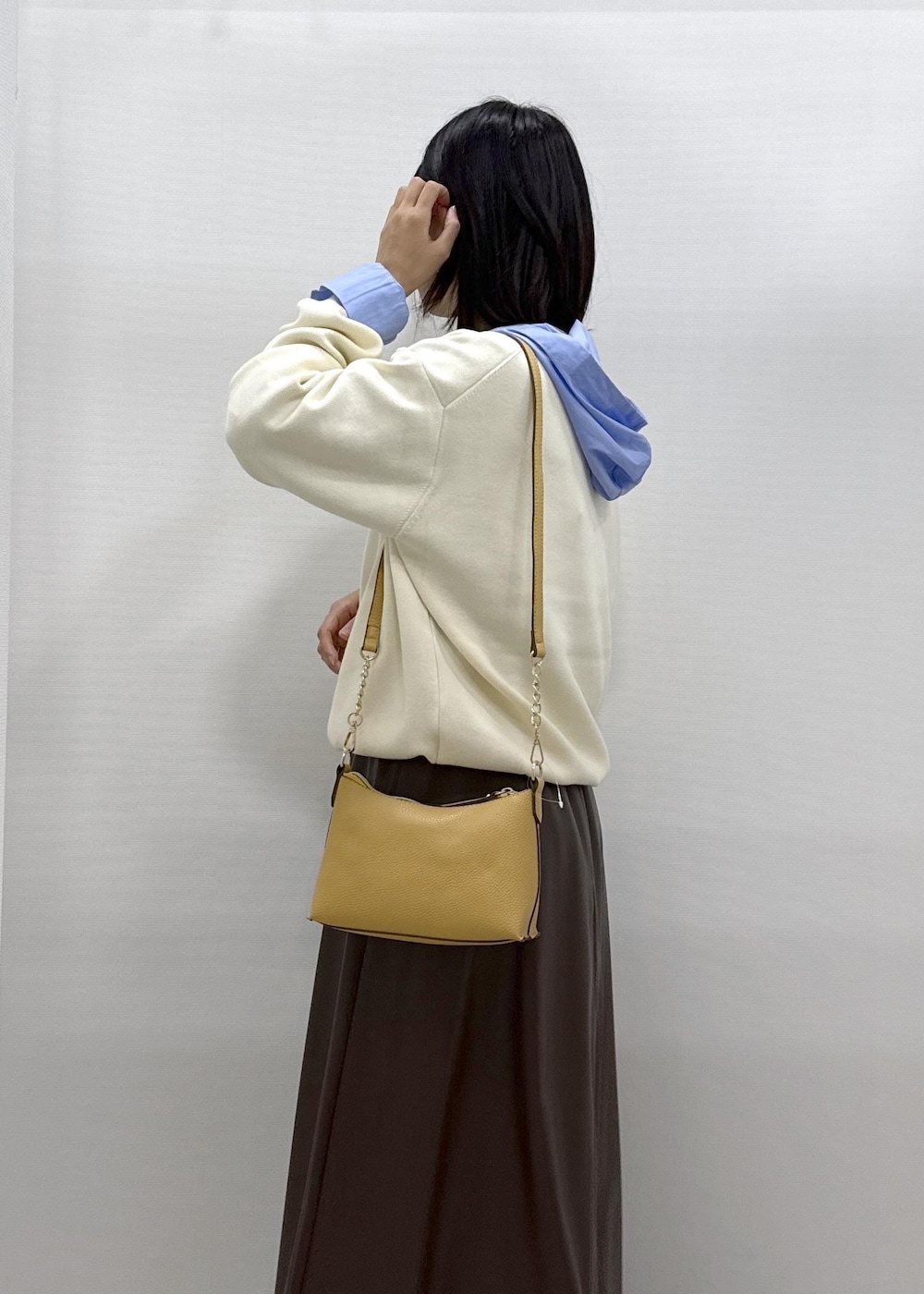 ブラウン系のショルダーバッグ、ブラウン系のスカート、ブラック系のパンプスを着用したレディースの秋コーディネートの10枚目の写真