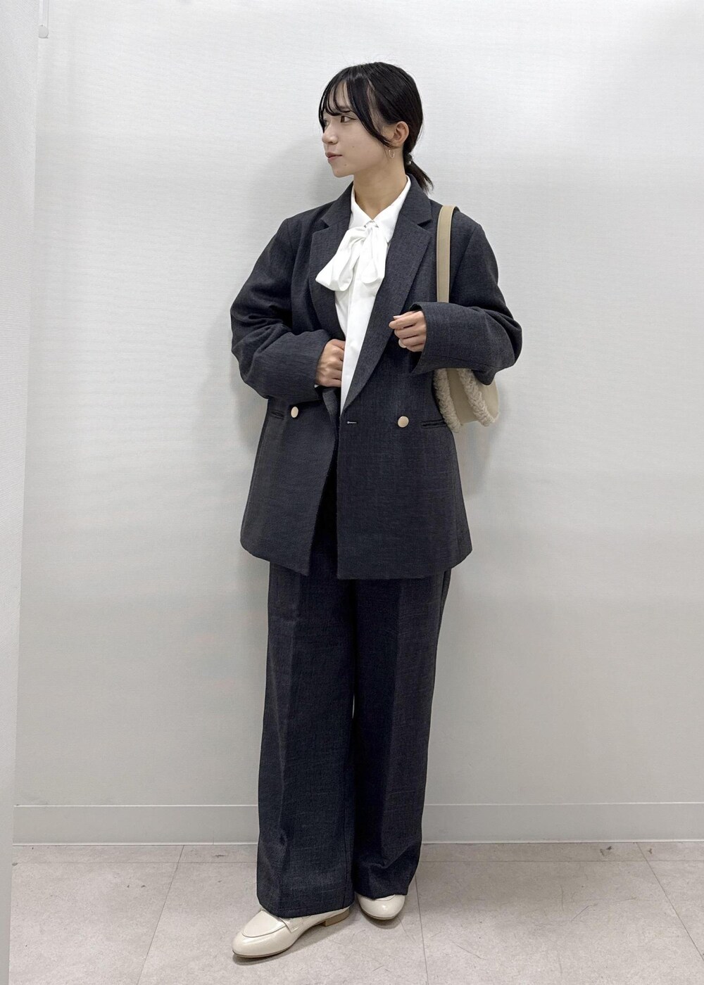 ホワイト系のパンプス、ホワイト系のシャツ/ブラウス、グレー系のテーラードジャケットを着用したレディースの秋コーディネートの9枚目の写真