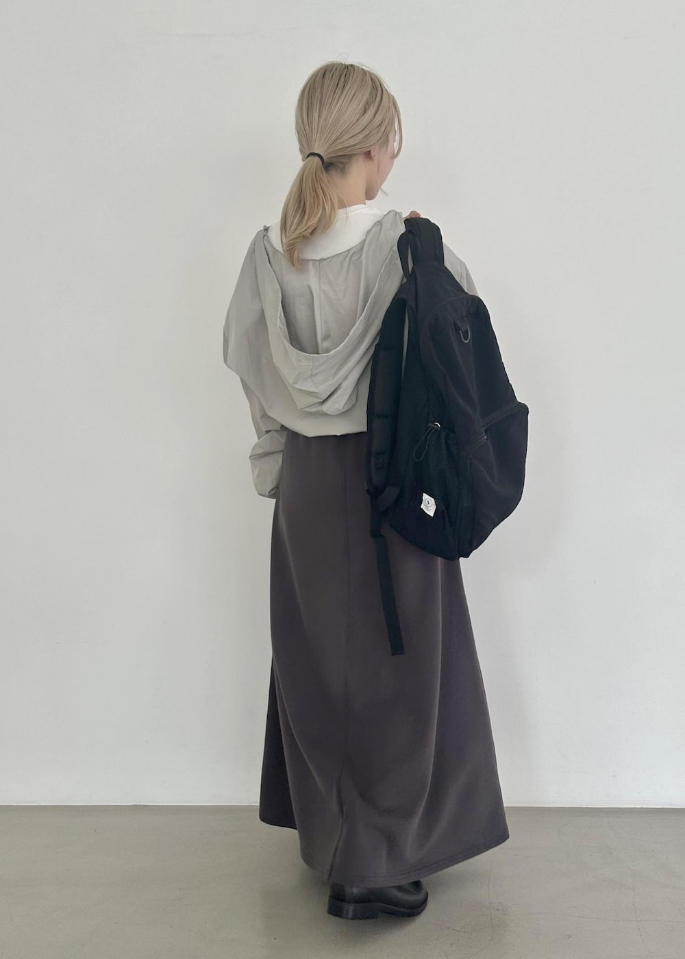 ブラック系のバックパック/リュック、グレー系のスカート、グレー系のその他アウターを着用したレディースの夏コーディネートの2枚目の写真