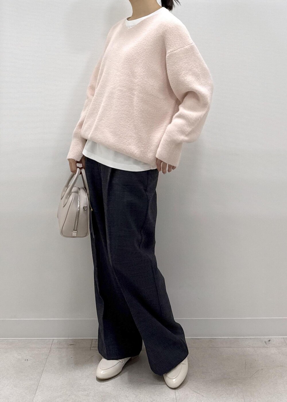 ホワイト系のパンプス、ピンク系のニット/セーター、ホワイト系のTシャツ/カットソーを着用したレディースの秋コーディネートの10枚目の写真