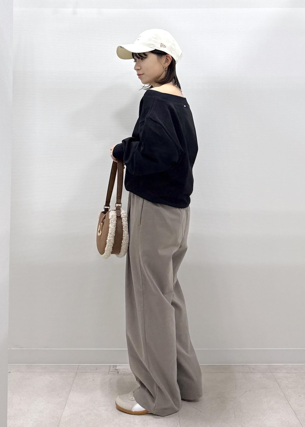 ベージュ系のその他パンツ、ブラック系のスウェット、ブラウン系のショルダーバッグを着用したレディースの秋コーディネートの3枚目の写真