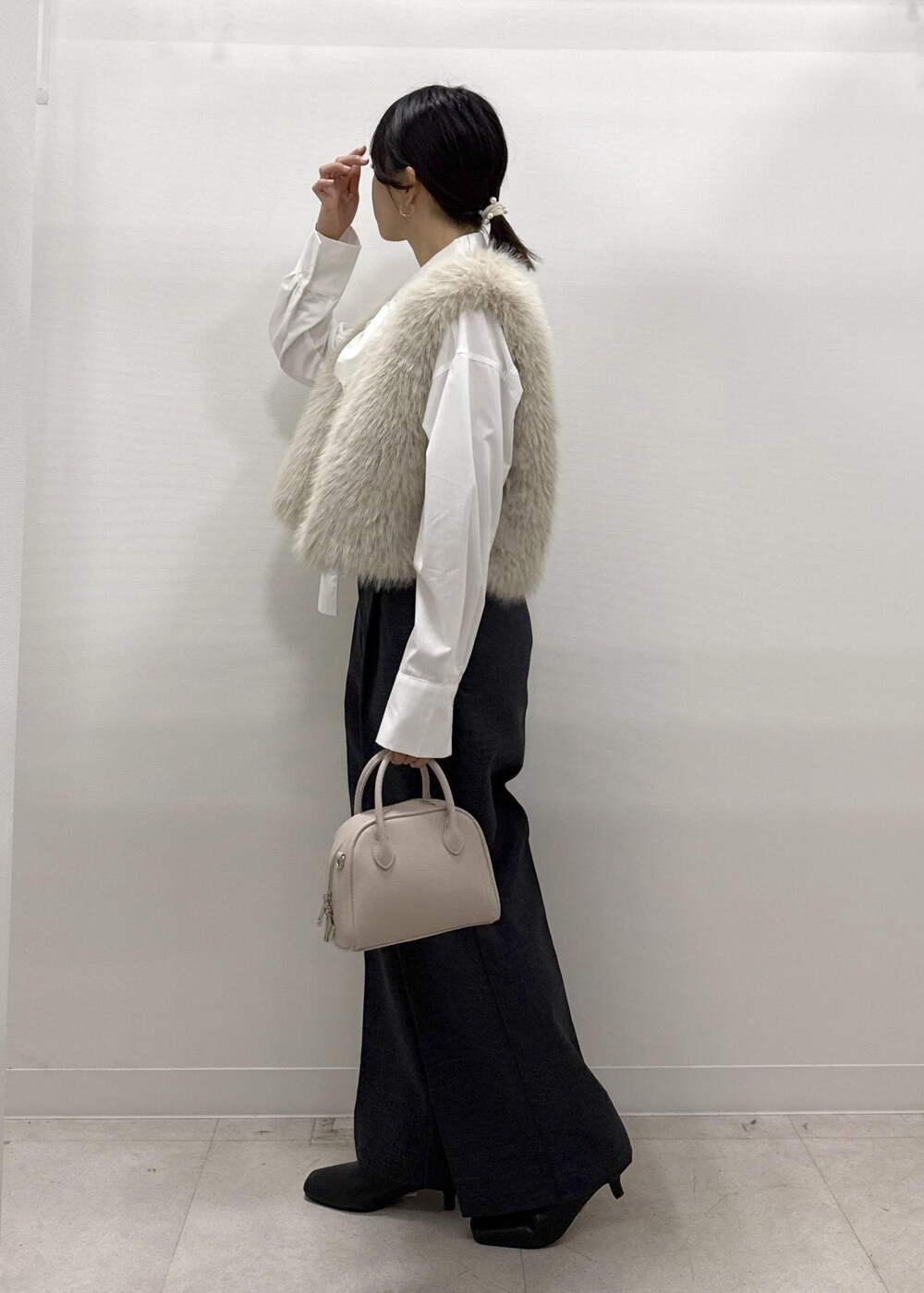 ベージュ系のベスト、ホワイト系のシャツ/ブラウス、グレー系のスラックスを着用したレディースの秋コーディネートの5枚目の写真