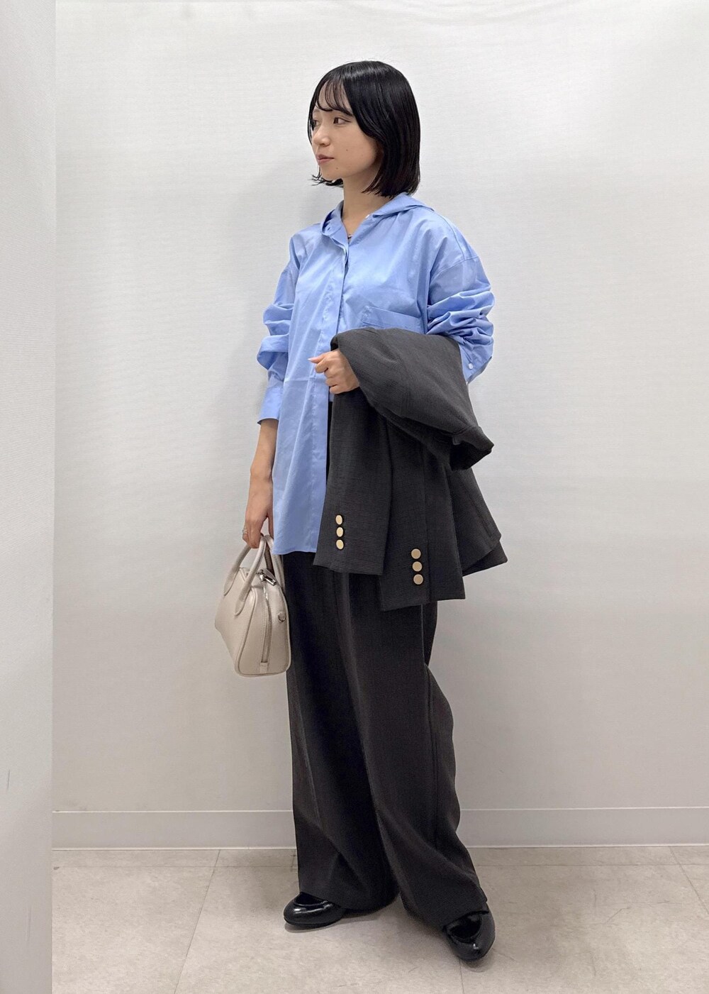 ブラック系のテーラードジャケット、ブラック系のスラックス、ブラック系のパンプスを着用したレディースの秋コーディネートの7枚目の写真