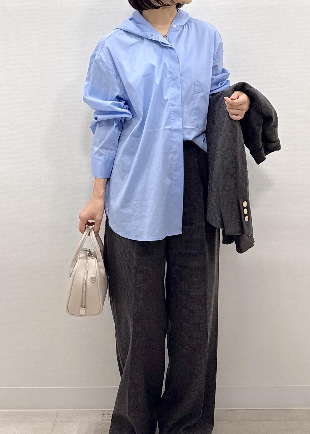 ブラック系のテーラードジャケット、ブラック系のスラックス、ブラック系のパンプスを着用したレディースの秋コーディネートの3枚目の写真